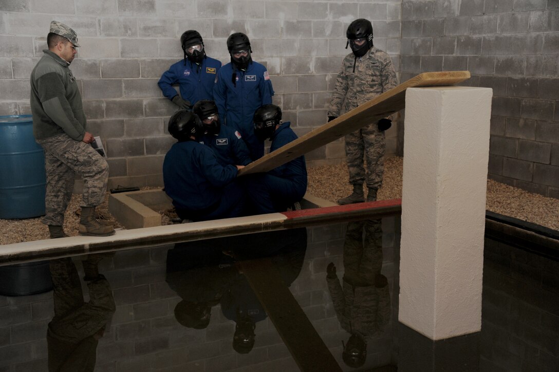 Six American and international astronauts work together to overcome an obstacle at the Project X leadership reaction course March 4, 2014, on Maxwell Air Force Base, Ala. The training opportunity was provided by the Academy of Military Sciences and coordinated with the NASA Johnson Space Center in Houston to give the astronauts a unique and challenging training opportunity with different scenarios and ways of meeting core leadership training requirements. (U.S. Air Force photo/Staff Sgt. Gregory Brook)
 