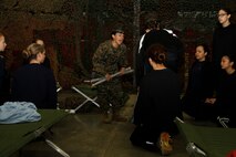 Sgt. Britni M. Garcia Green, a Platoon 4017, Company N, 4th Recruit Training Battalion, Marine Corps Recruit Depot Parris Island drill instructor, speaks with volume and intensity as she instructs poolees on how to properly break down a sleeping cot during Recruiting Station Kansas City's all-female pool function at  9th Marine Corps District Headquarters' Building 712 March 15, 2014. The purpose of the pool function was to give poolees their first glimpse of what to expect during recruit training.