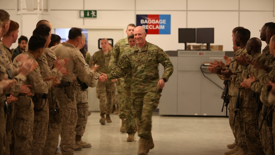Army Capt. Matt Anderson, a soldier formerly with with the 1st Brigade, 4th Infantry Division, shakes hands with Marines and soldiers who gathered to give Anderson and his fellow soldiers a "Hero's Welcome" at the passenger terminal aboard Camp Bastion, Afghanistan, March 13, 2014. Anderson and four other soldiers were participants in Operation Proper Exit, a program for wounded service members who choose to come back to Afghanistan after recovering from combat injuries in order to find closure.