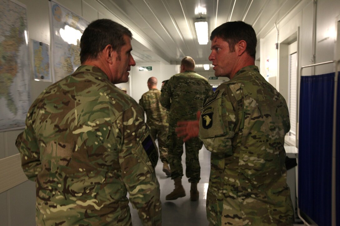 Army Sgt. Noah Galloway (retired), right, a soldier formerly with with the 101st Airborne, 1st Battalion, 502nd Infantry Regiment, speaks with a British chaplain as they tour the hospital aboard Camp Bastion, Afghanistan, March 13, 2014. Galloway and four other soldiers were participants in Operation Proper Exit, a program for wounded service members who choose to come back to Afghanistan after recovering from combat injuries in order to find closure.