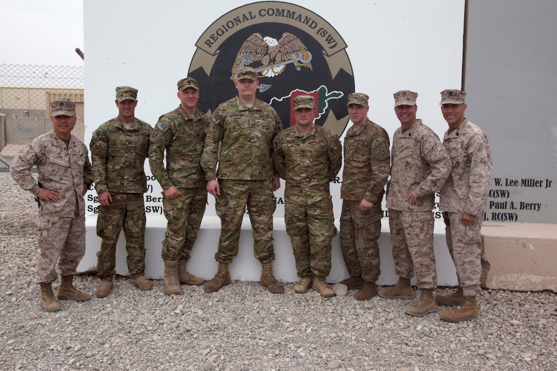 From left to right: Brig. Gen. Daniel Yoo, commanding general of Regional Command (Southwest), Army Sgt. Noah Galloway (retired), Capt. Matt Anderson, Sgt. Daniel Harrison (retired), Spc. Andrew Miller (retired), Sgt. Ryan McIntosh, Sgt. Maj. Douglas Berry Jr., sergeant major of Regional Command (Southwest) and Master Chief Petty Officer Frank Dominguez, command master chief of Regional Command (Southwest) pose for a photo aboard Camp Leatherneck, Afghanistan, March 13, 2014. The soldiers were participants in Operation Proper Exit, a program for wounded service members who choose to come back to Afghanistan after recovering from combat injuries in order to find closure.