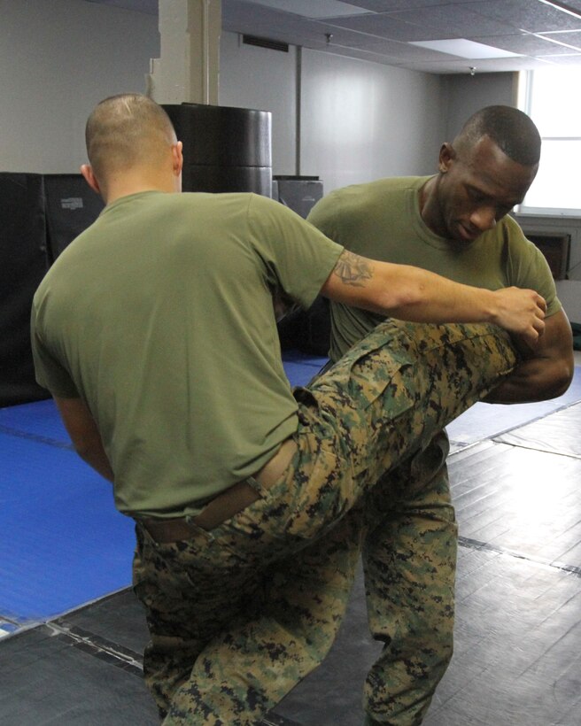 GARDEN CITY, N.Y. - Sgt. Malik S. King, purchasing agent, warehouse chief, color sergeant, and now martial arts instructor for 1st Marine Corps District and a native of Hempstead N.Y., demonstrates a round-kick counter with Sgt. Edgar Caballero, an Austin, Texas, native now a legal clerk assigned to 1MCD on Feb. 12 in the unit's headquarters. King is exercising the second step in EDIP, explain, demonstrate, imitate and practice. (U.S. Marine Corps photo by Lance Cpl. Brandon Thomas).