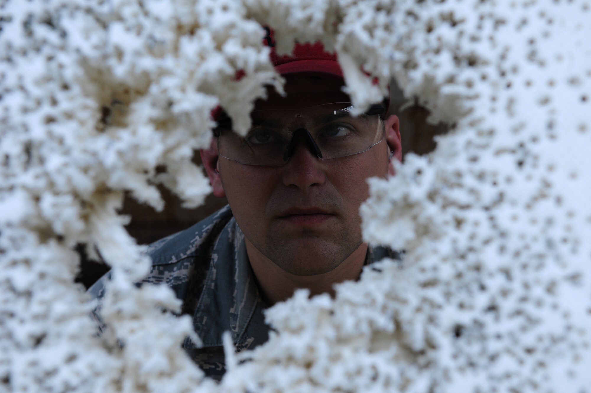 U.S. Air Force Senior Airman John Parsons, 18th Security Forces Squadron Combat Arms instructor, looks at a shooting target at the 18th Security Forces Squadron Combat Arms firing range on Kadena Air Base, Japan, Feb. 28, 2014. The Combat Arms team trains and qualifies security forces personnel, office of special investigations personnel and service members tasked to deploy on weapons such as the M-4 carbine rifle and the M-9 pistol. (U.S. Air Force photo by Airman 1st Class Hailey R. Staker)
