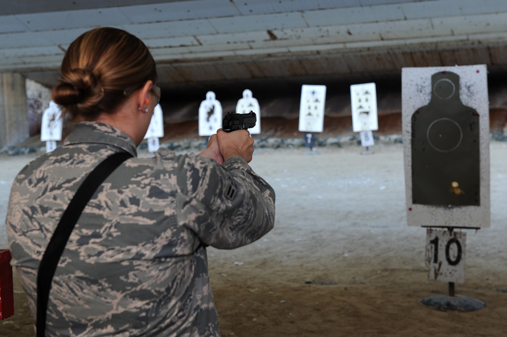 U.S. Air Force Airman 1st Class Jamie Kirch, 18th Security Forces Squadron response force member, fires an M-9 pistol during weapons qualification at the 18th SFS Combat Arms firing range on Kadena Air Base, Japan, Feb. 28, 2014. The Combat Arms team trains and qualifies security forces personnel, office of special investigations personnel and service members tasked to deploy on weapons such as the M-4 carbine rifle and the M-9. (U.S. Air Force photo by Airman 1st Class Hailey R. Staker)