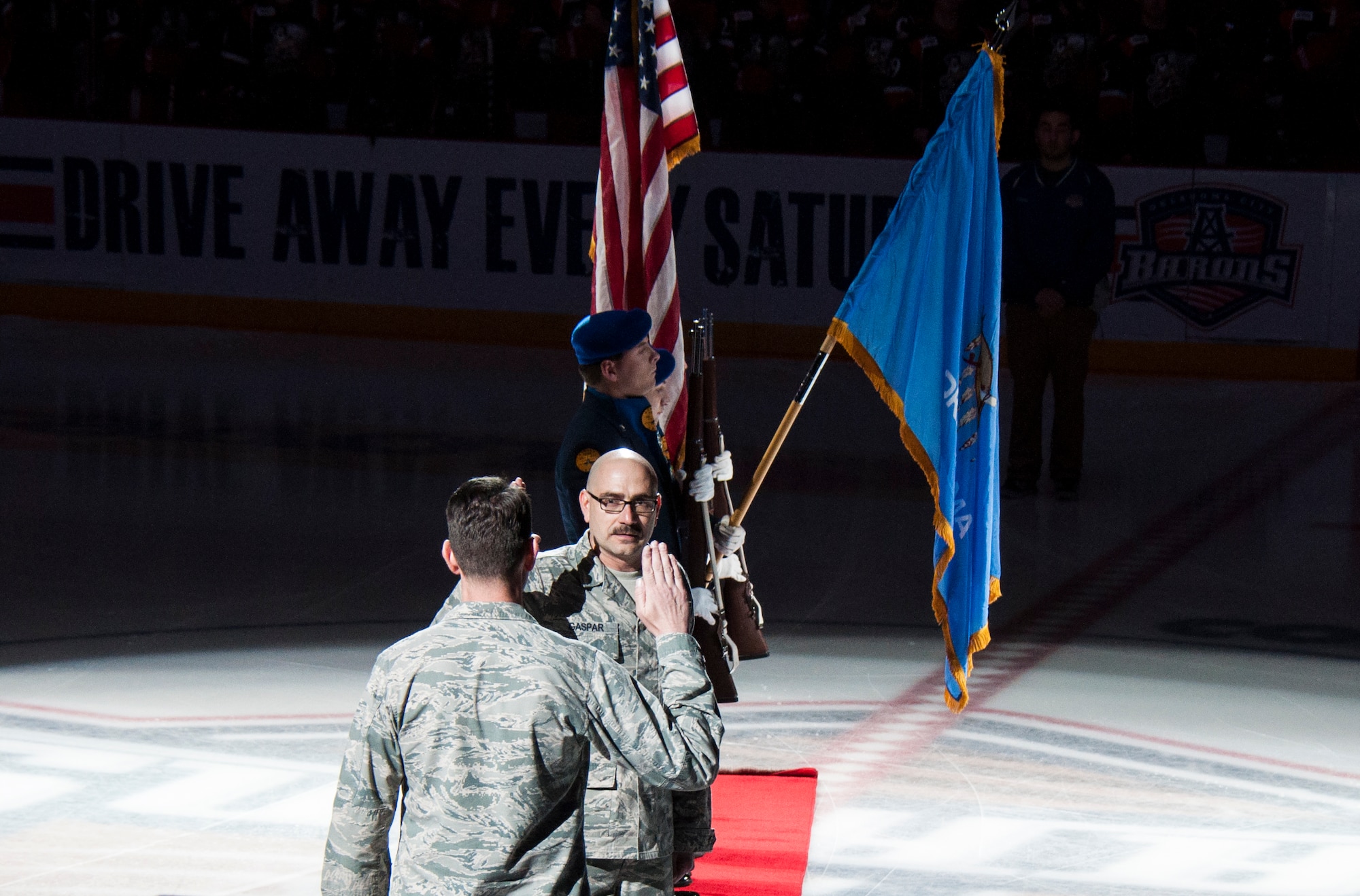 Senior Master Sergeant Robert Gaspar receives the Oath of Enlistment from Maj. Charles Hicks Saturday March 15, 2014.  Gaspar and Hicks, both members of 507th Operations Group Intelligence, took to center ice prior to an Oklahoma City Barons hockey game for the re-enlistment.  Also on hand presenting the colors was the Midwest City AFJROTC.  Senior Master Sergeant Gaspar’s re-enlistment will give him 34 years of service marking the end of his career.  Gaspar, a long time Barons season ticket holder, said taking the oath at center ice was nerve wracking, but also one of his career highlights.  (U.S. Air Force photo/Senior Airman Mark Hybers)     