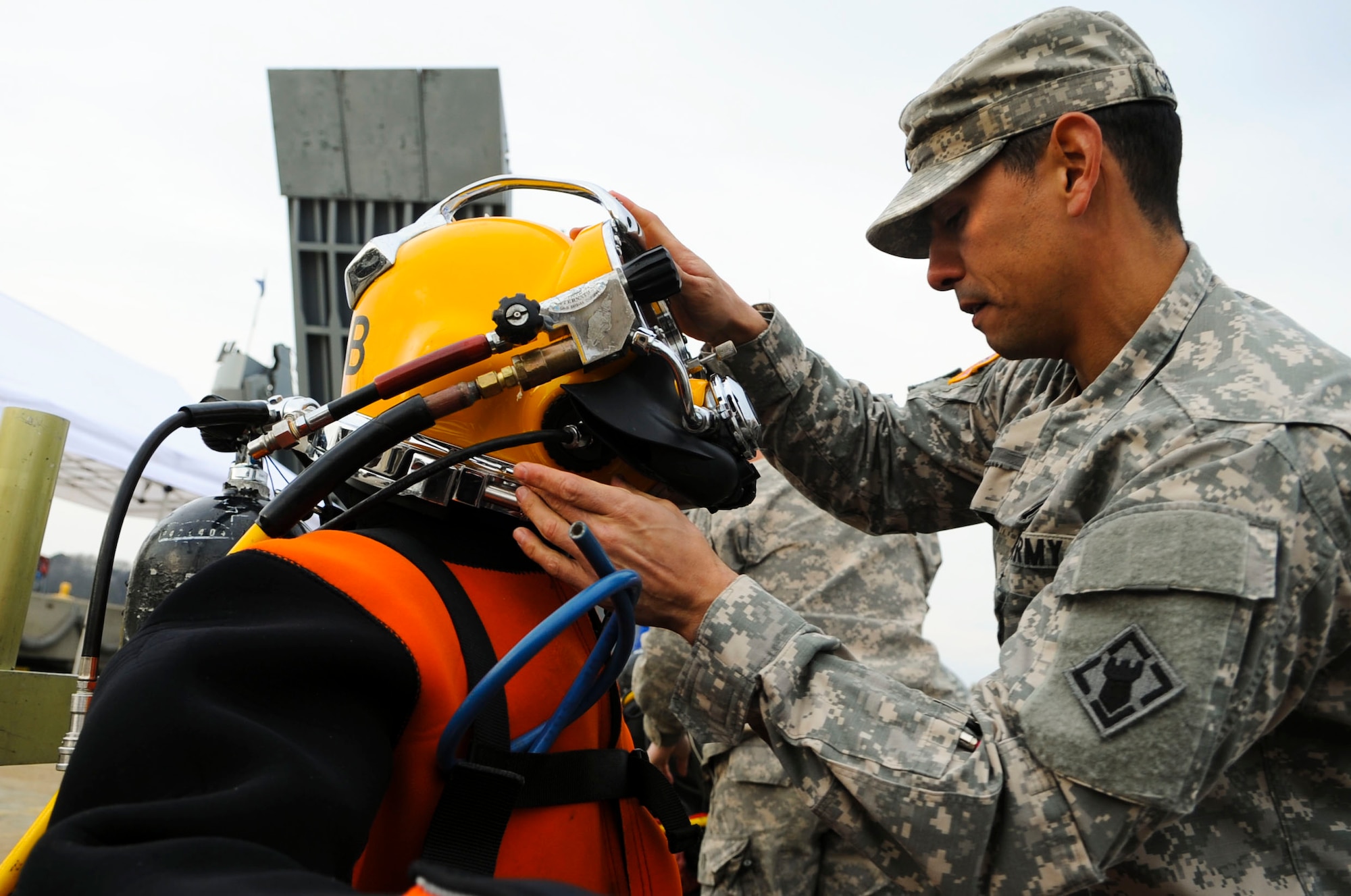 U.S. Army Staff Sgt. Ray Cortwright, 74th Engineer Detachment (Dive), 30th Engineer Battalion, 20th Engineer Brigade dive supervisor, adjusts dive equipment before a training scenario at Fort Eustis, Va., March 12, 2014. Divers must dive once every 90 days and at least eight times a year to remain proficient. (U.S. Air Force photo by Senior Airman Austin Harvill/Released)