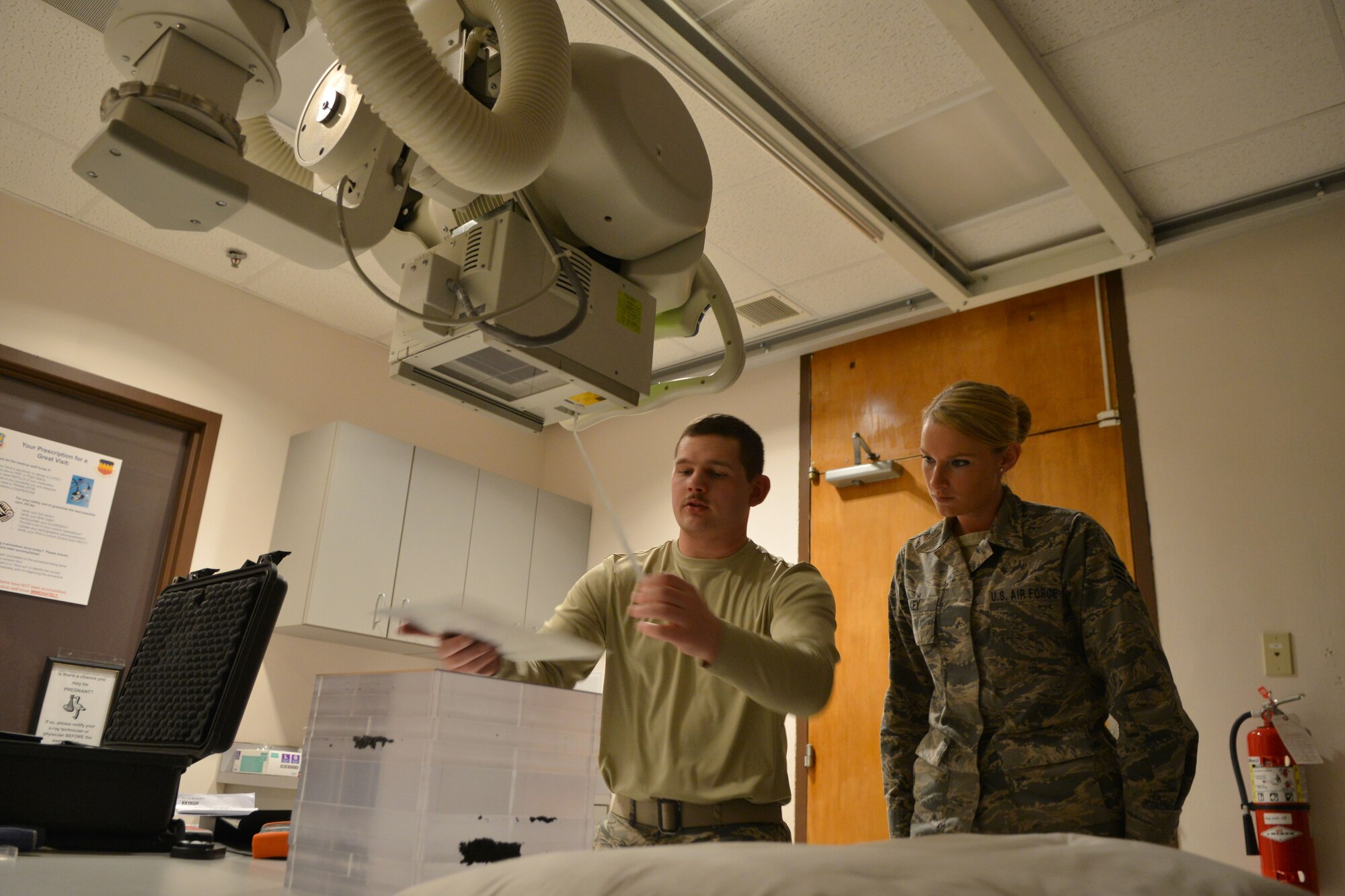 U.S. Air Force Senior Airman Jeremy Nott, 20th Medical Support Squadron medical maintenance technician, and Staff Sgt. Lauren Key, 20th MDSS medical maintenance NCO in charge, prepare to measure the distance from the X-ray machine to the table, Shaw Air Force Base, S.C., March 13, 2014. The purpose for the X-ray calibration and all the test involved are to make sure the density is correct and the radiation into the patient is not to much for the patient.(U.S. Air Force photo by Senior Airman Ashley L. Gardner/Released)