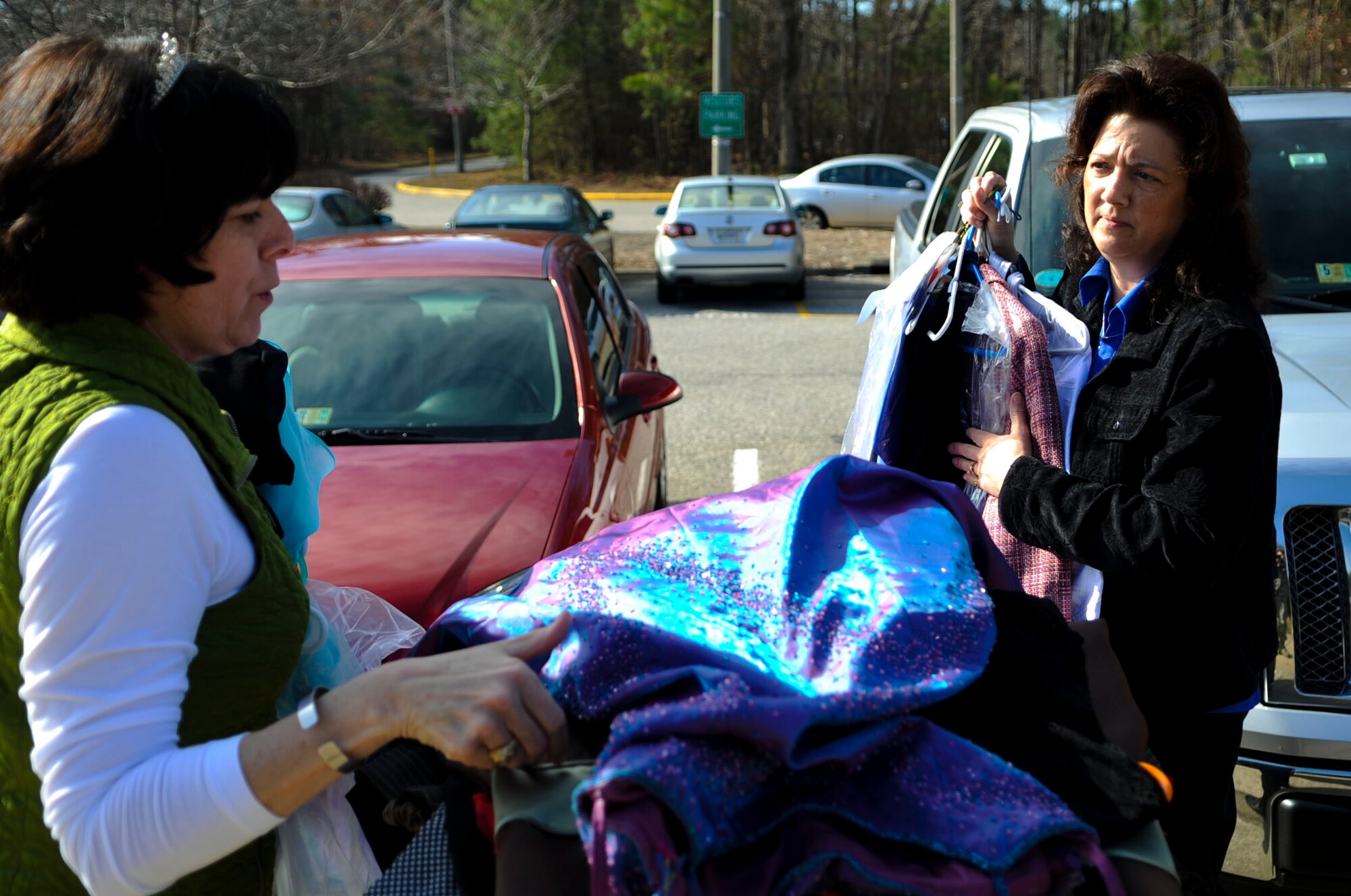 From left, Karen Halverson and Holly Dailey, Fort Eustis Spouses’ Club members, load clothes for donation in Newport News, Va., March 10, 2014. The clothes will go to a local high school to help teens who need dresses or suits for prom, business trips and internships. (U.S. Air Force photo by Senior Airman Austin Harvill/Released) (photo cropped, color balanced, and contrasted to improve image)