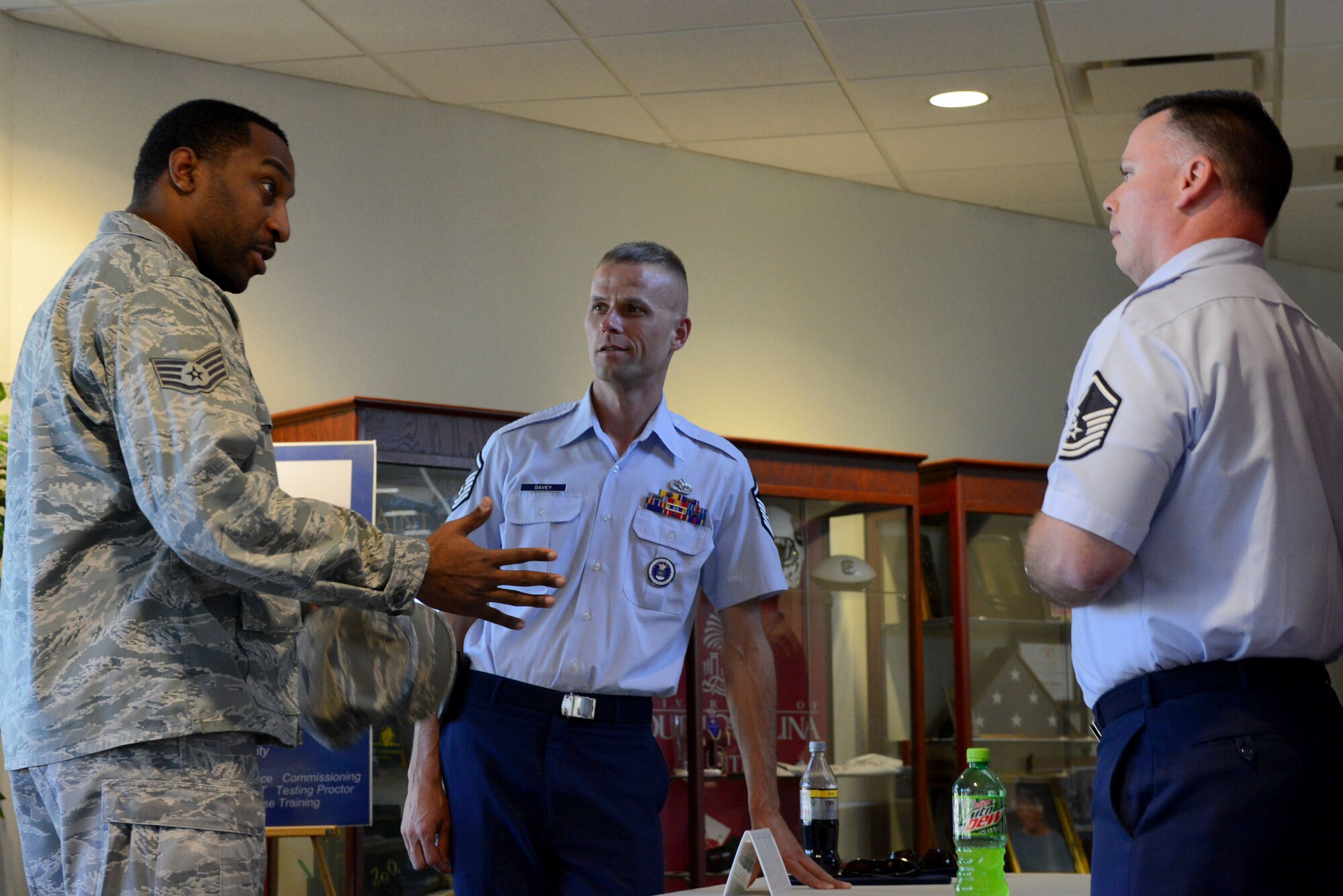 [From left] U.S. Air Force Staff Sgt. Aaron Trammell, 20th Contracting Squadron contingency contract officer, speaks with Master Sgt. Phillip Davey and Master Sgt. Michael Burchfield, 337th Recruiting Squadron recruiters, during a developmental special duty job fair at the Spratt Education Center, Shaw Air Force Base, S.C., March 14, 2014. NCOs from 10 DSDs to include military training leaders, military training instructors and first sergeants spoke about their special duties and what to expect when participating in them. (U.S Air Force photo by Airman 1st Class Jensen Stidham/Released)