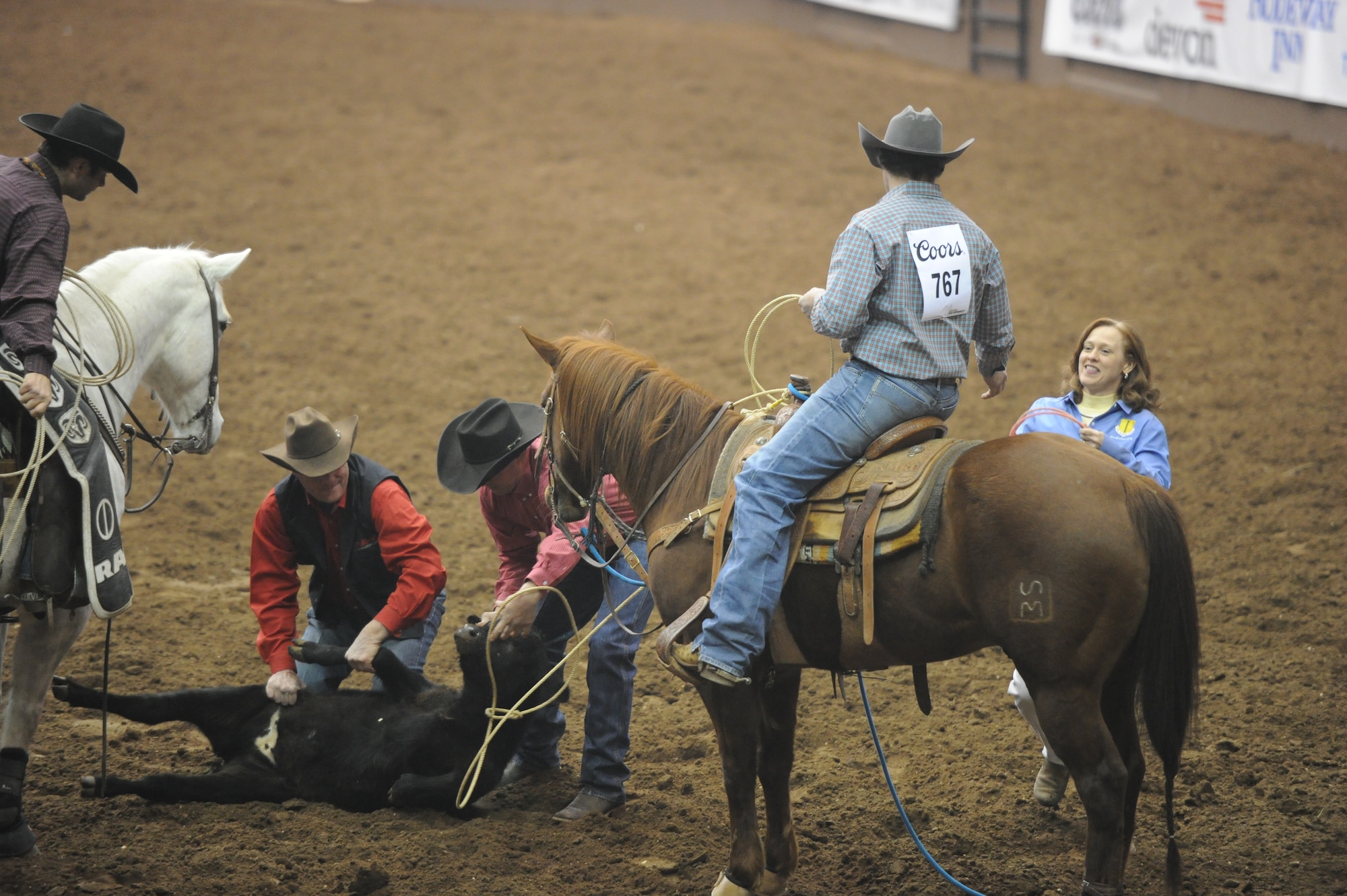 SAN ANGELO, Texas -- Col. Kimberlee Joos, 17th Training Wing Commander, hands the tie-down rope, or piggin' string, back to Jesse Clark, San Angelo Stock Show and Rodeo competitor, during the San Angelo Stock Show and Rodeo’s Military Appreciation Night at the Foster Communication Coliseum here Feb. 26. The San Angelo Stock Show and Rodeo Drill Team Ambassadors presented the American and service flags during the night to honor all who serve or have served. (U.S. Air Force photo/ Staff Sgt. Laura R. McFarlane)