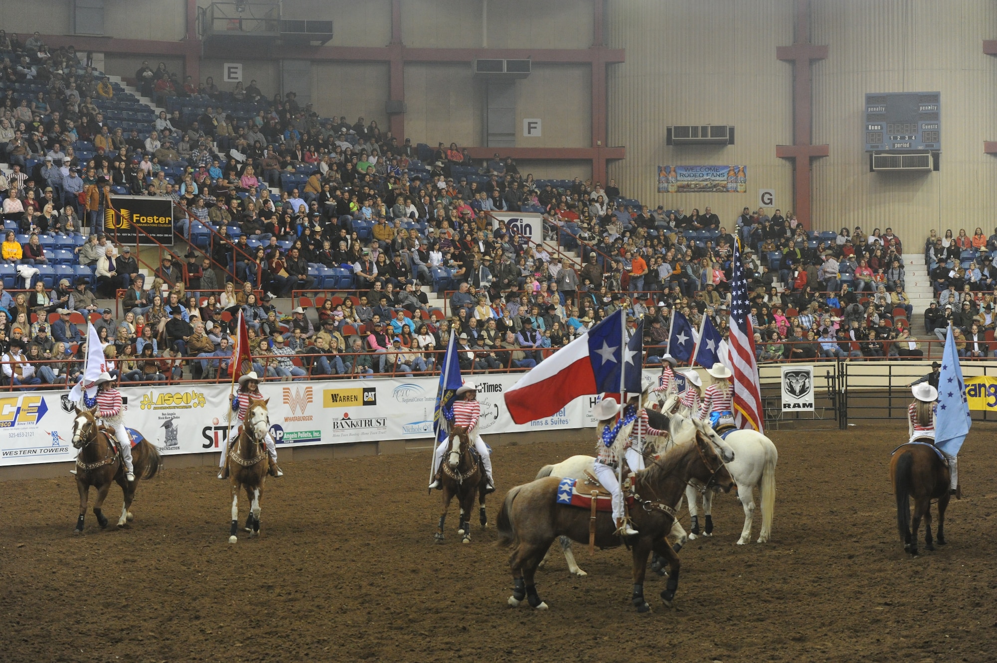 SAN ANGELO, Texas --The San Angelo Stock Show and Rodeo Drill Team Ambassadors present the American and service flags during the San Angelo Stock Show and Rodeo’s Military Appreciation Night at the Foster Communication Coliseum here Feb. 26. Goodfellow Air Force Base’s Patriotic Blue sang the national anthem during the flag presentation. (U.S. Air Force photo/ Staff Sgt. Laura R. McFarlane)
