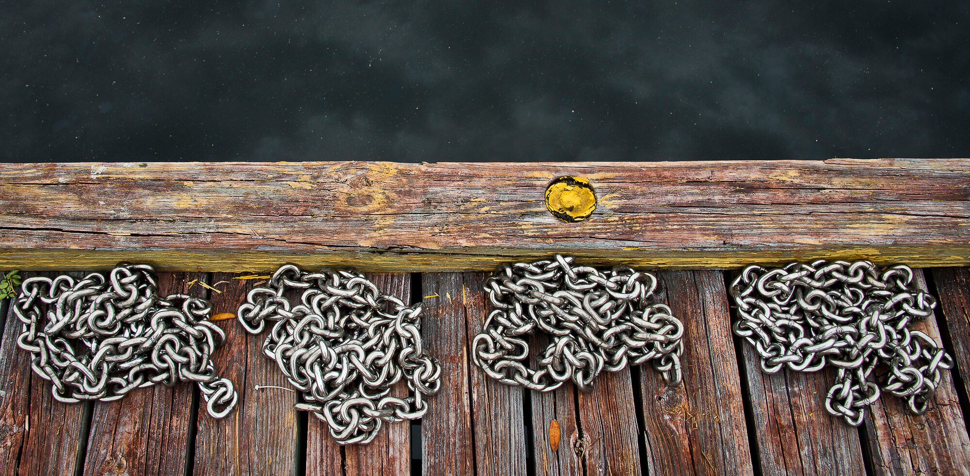Anchor chains are laid out on the dock prior to being attached to the base's new restricted area buoys March 11 at Eglin Air Force Base, Fla.  The Coast Guard posted approximately 40 buoys along the base’s coastline from Post’l Point to the Bayview Club.  The anchored buoys, spread approximately 700 feet from each other, are a force protection enterprise by the base to identify Eglin waterways.  According to the code of federal regulations (CFR 334.700-748), all vessels and other craft are permitted access to the restricted area, but could be subject to identification checks by Air Force patrol boats.  During times of high security threats against Eglin or Hurlburt Field, all entry, transit, anchoring or drifting within the restricted areas is prohibited without permission from the respective base commander or authorized representative.  (U.S. Air Force photo/Samuel King Jr.)