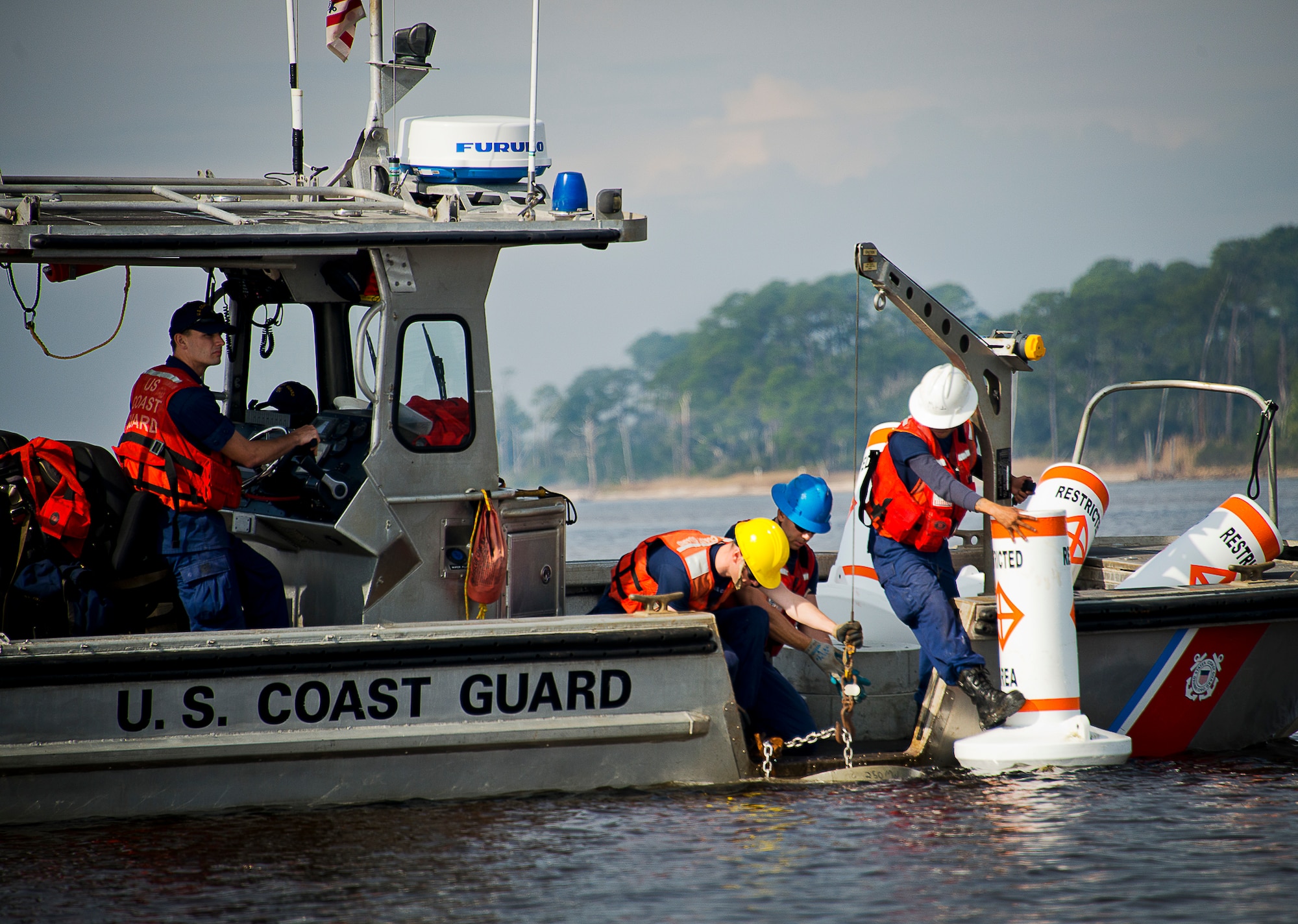 Aids to Navigation Team members from Coast Guard Station Pensacola prepare to post a restricted area buoy March 11 at Eglin Air Force Base, Fla.  The Coast Guard posted approximately 40 buoys along the base’s coastline from Post’l Point to the Bayview Club.  The anchored buoys, spread approximately 700 feet from each other, are a force protection enterprise by the base to identify Eglin waterways.  According to the code of federal regulations (CFR 334.700-748), all vessels and other craft are permitted access to the restricted area, but could be subject to identification checks by Air Force patrol boats.  During times of high security threats against Eglin or Hurlburt Field, all entry, transit, anchoring or drifting within the restricted areas is prohibited without permission from the respective base commander or authorized representative.  (U.S. Air Force photo/Samuel King Jr.)