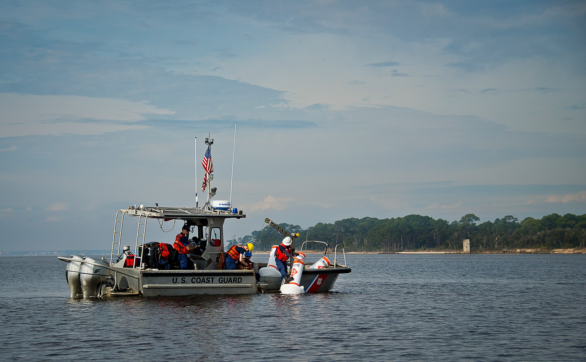 Aids to Navigation Team members from Coast Guard Station Pensacola prepare to post a restricted area buoy March 11 at Eglin Air Force Base, Fla.  The Coast Guard posted approximately 40 buoys along the base’s coastline from Post’l Point to the Bayview Club.  The anchored buoys, spread approximately 700 feet from each other, are a force protection enterprise by the base to identify Eglin waterways.  According to the code of federal regulations (CFR 334.700-748), all vessels and other craft are permitted access to the restricted area, but could be subject to identification checks by Air Force patrol boats.  During times of high security threats against Eglin or Hurlburt Field, all entry, transit, anchoring or drifting within the restricted areas is prohibited without permission from the respective base commander or authorized representative.  (U.S. Air Force photo/Samuel King Jr.)