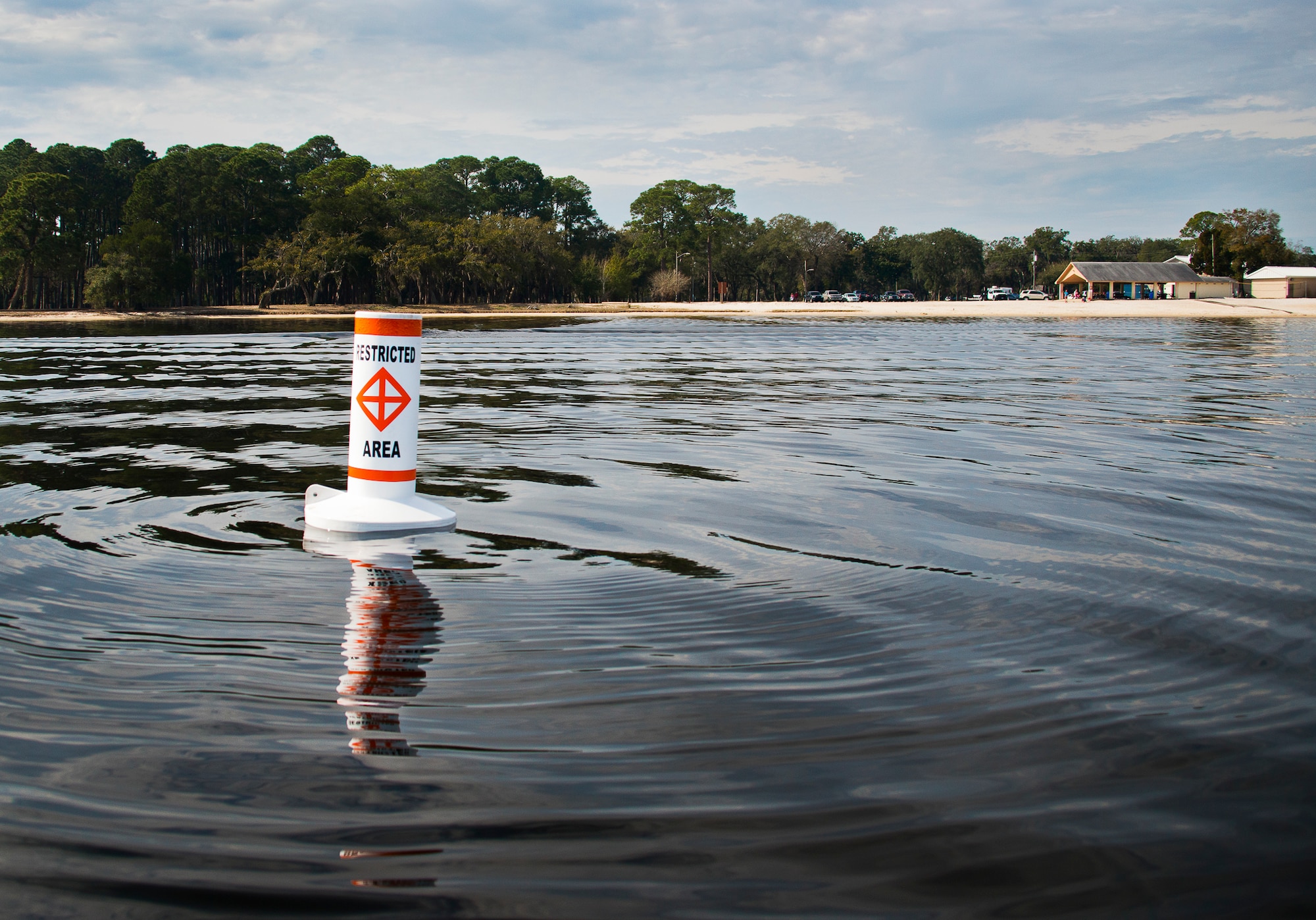 A restricted area buoy bobs in the water by Post’l Point at Eglin Air Force Base, Fla., March 11.  The Coast Guard posted approximately 40 buoys along the base’s coastline from Post’l Point to the Bayview Club.  The anchored buoys, spread approximately 700 feet from each other, are a force protection enterprise by the base to identify Eglin waterways.  According to the code of federal regulations (CFR 334.700-748), all vessels and other craft are permitted access to the restricted area, but could be subject to identification checks by Air Force patrol boats.  During times of high security threats against Eglin or Hurlburt Field, all entry, transit, anchoring or drifting within the restricted areas is prohibited without permission from the respective base commander or authorized representative.  (U.S. Air Force photo/Samuel King Jr.)