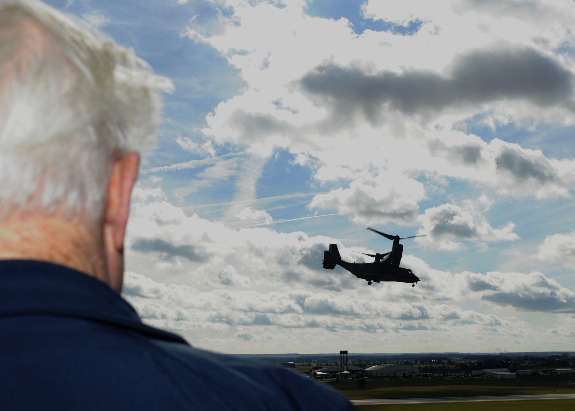 Maurice Howard Bailey, former prisoner of war during World War II and former Royal Air Force No. 15 Squadron wireless operator, watches a CV-22 Osprey fly past the air traffic control tower March 7, 2014, on RAF Mildenhall, England. Bailey flew only a few missions before being shot down while en route to Germany. As the only uninjured survivor of the plane crash, he managed to survive in enemy territory for several weeks before being captured near the border of Switzerland. (U.S. Air Force photo by Airman 1st Class Preston Webb/Released)