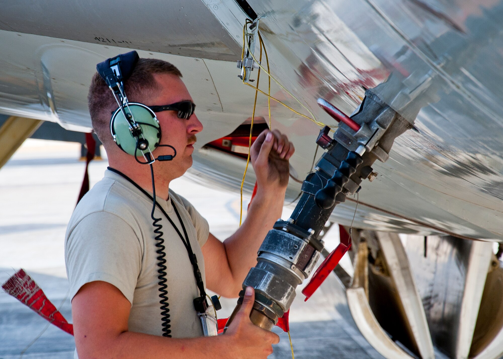 Air Force Staff Sgt. Travis Turner, 380th Expeditionary Aircraft Maintenance Squadron Sentry Aircraft Maintenance Unit E-3 crew chief, refuels an E-3 Sentry at an undisclosed location in Southwest Asia, March 12, 2014. Turner is a native of Columbia Falls, Mont., and is deployed from Tinker Air Force Base, Okla. (U.S. Air Force photo by Staff Sgt. Michael Means/Released)