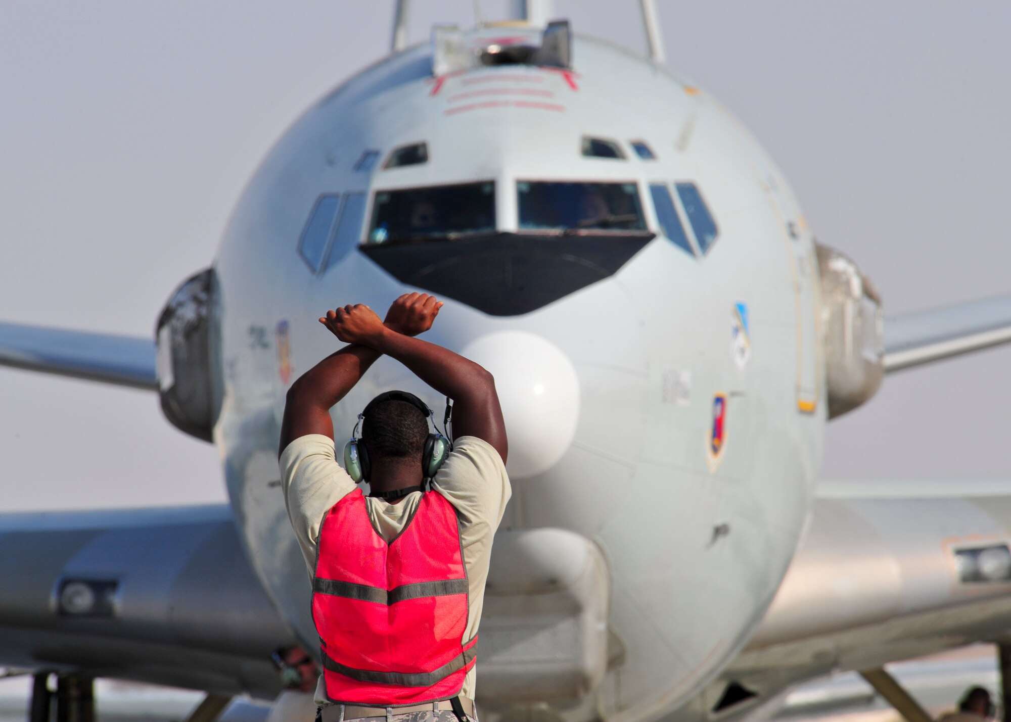 Air Force Staff Sgt. Clifford Scott, 380th Expeditionary Aircraft Maintenance Squadron Sentry Aircraft Maintenance Unit E-3 computers technician, marshals in an E-3 Sentry at an undisclosed location in Southwest Asia, March 12, 2014. Scott is a native of Baltimore, Md., and is deployed from Tinker Air Force Base, Okla. (U.S. Air Force photo by Staff Sgt. Michael Means/Released)