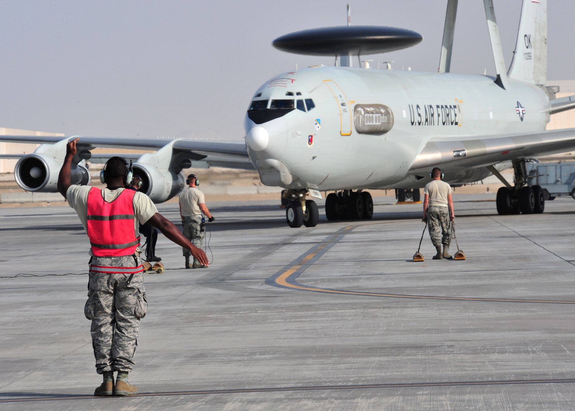 Air Force Staff Sgt. Clifford Scott, 380th Expeditionary Aircraft Maintenance Squadron Sentry Aircraft Maintenance Unit E-3 computers technician, marshals in an E-3 Sentry at an undisclosed location in Southwest Asia, March 12, 2014. Scott is a native of Baltimore, Md., and is deployed from Tinker Air Force Base, Okla. (U.S. Air Force photo by Staff Sgt. Michael Means/Released)