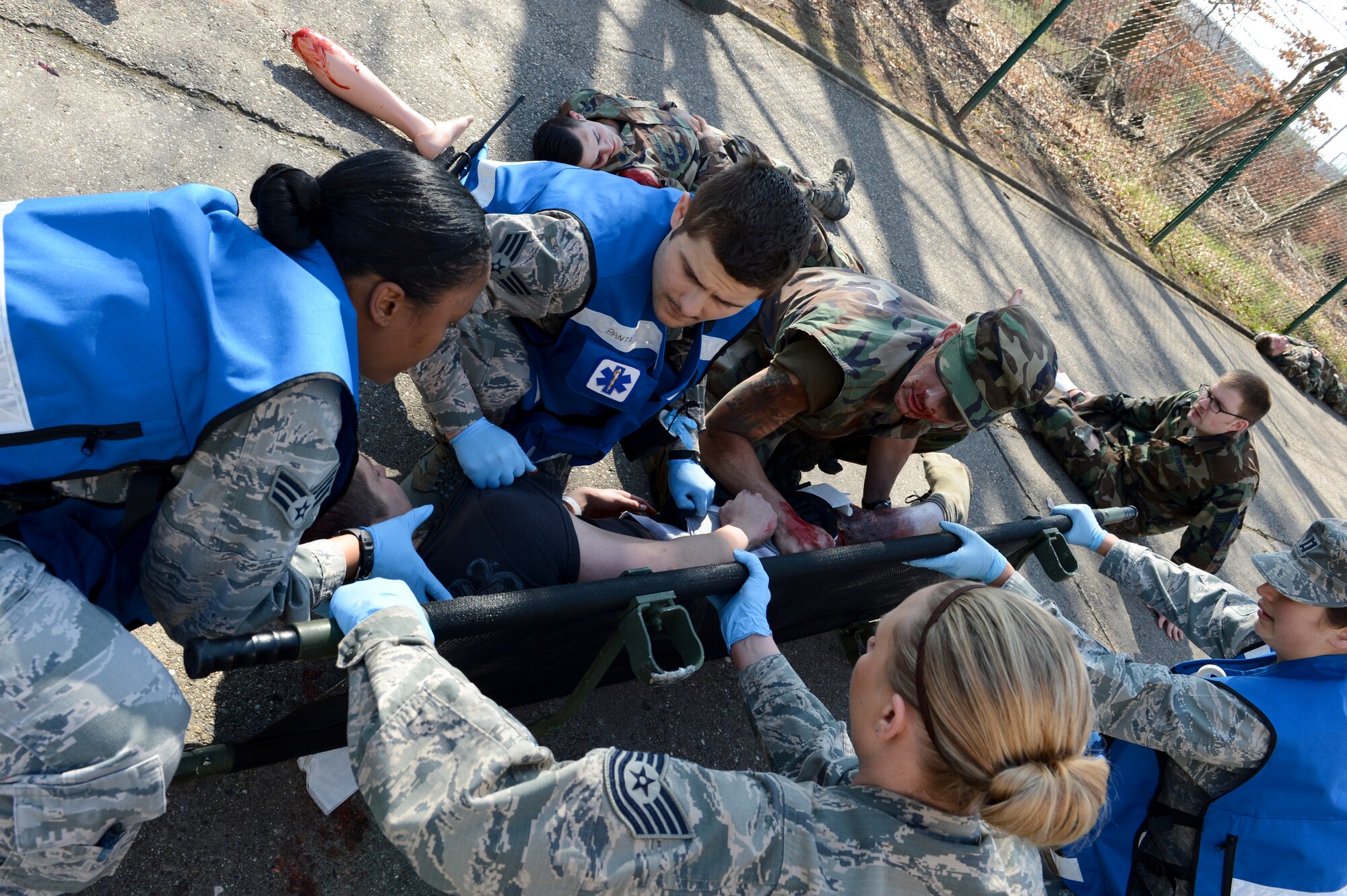 A team of first responders put a simulated patient who has suffered serious injuries on a stretcher during a mass casualty exercise March 13, 2014, Ramstein Air Base, Germany. The 86th Medical Group hosted a mass casualty training to familiarize first responders with the scene of a disaster or a catastrophe. (U.S. Air Force Photo/Airman 1st Class Michael Stuart)