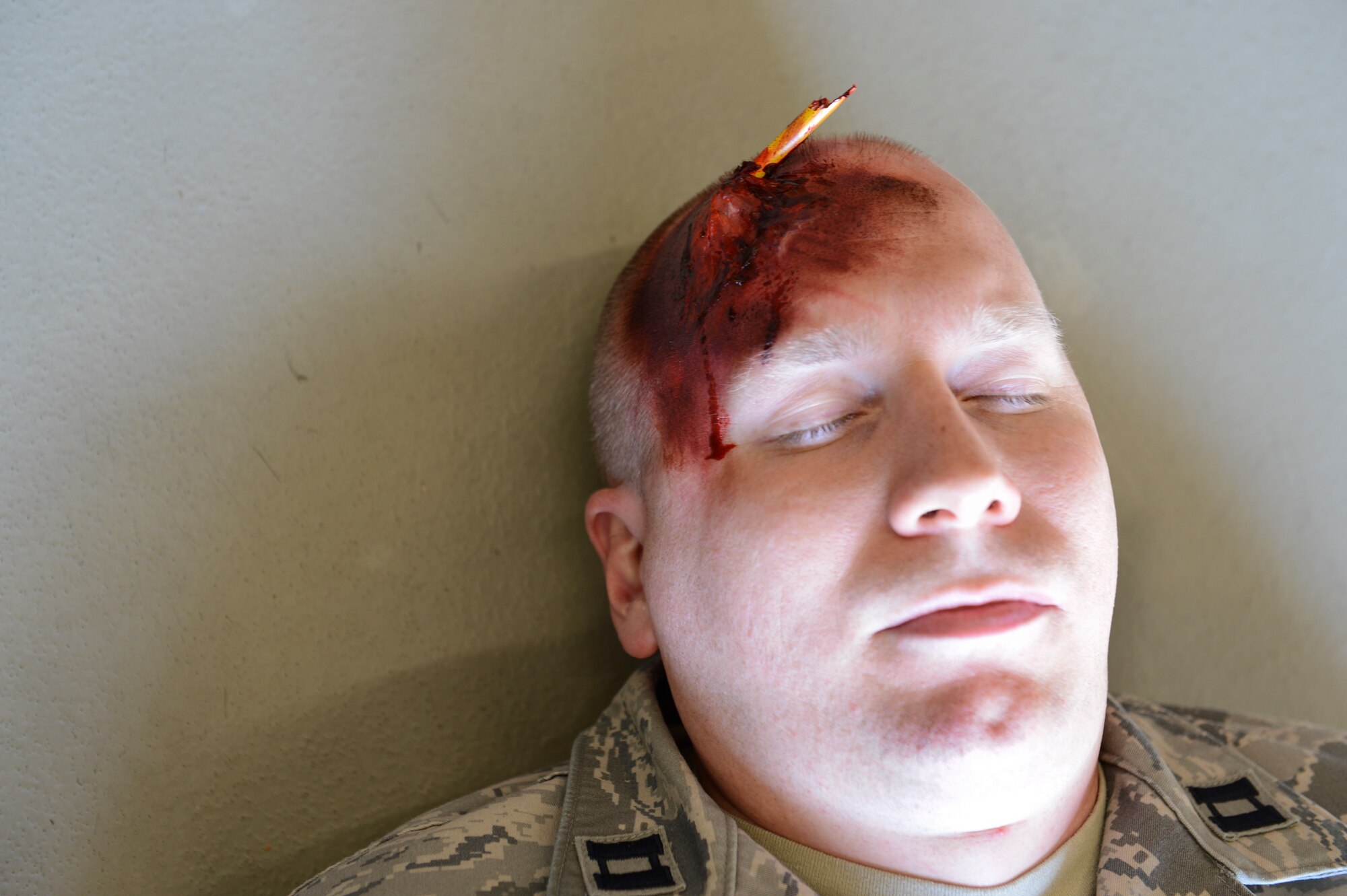 A mass casualty training victim simulates a state of unconsciousness while he awaits first responders to arrive on scene during an exercise March 13, 2014, Ramstein Air Base, Germany. The 86th Medical Group hosted a mass casualty training to familiarize first responders with the scene of a disaster or a catastrophe. (U.S. Air Force Photo/Airman 1st Class Michael Stuart)