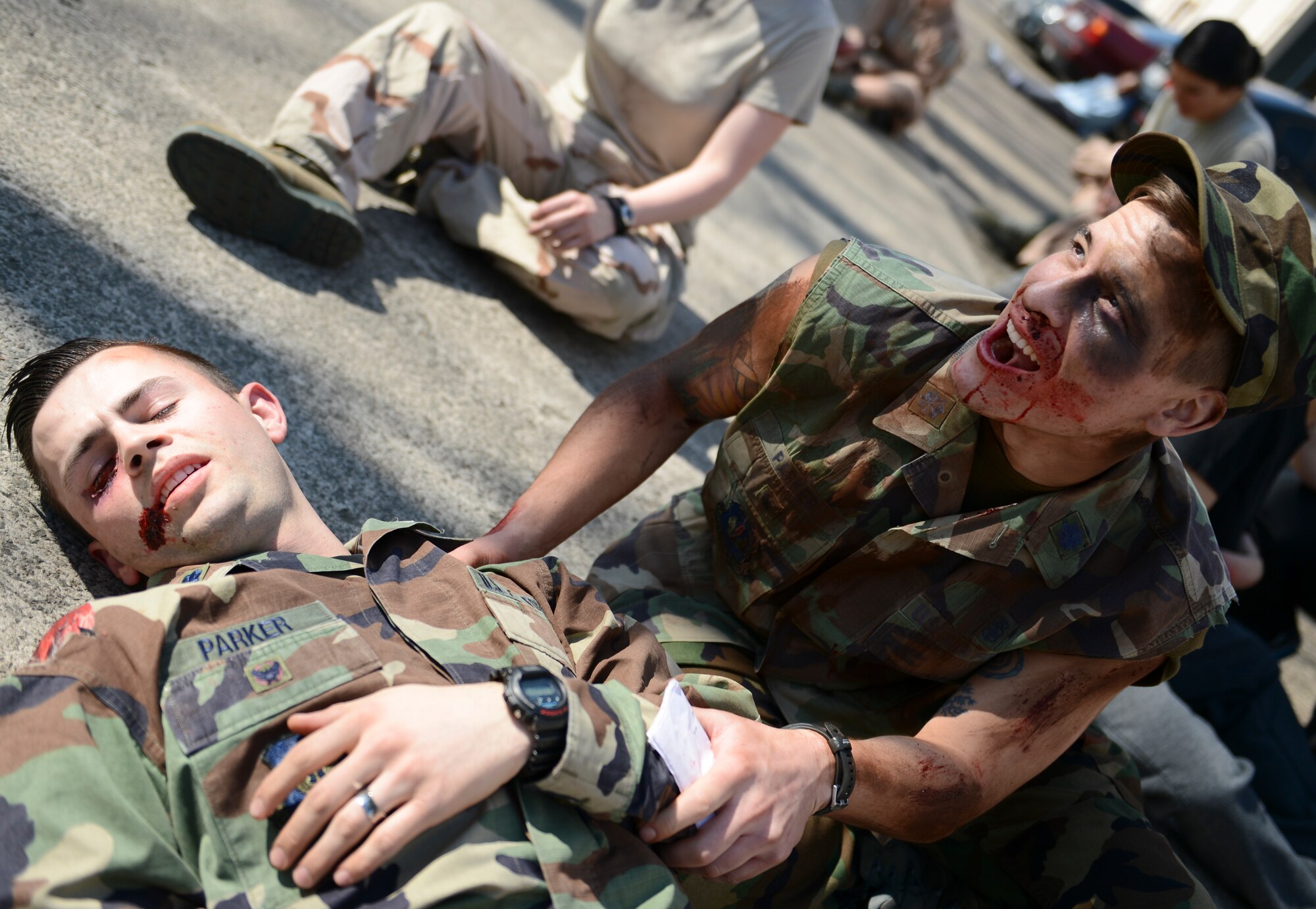 A mass casualty training victim simulates a cry of agony over the loss of his friend March 13, 2014, Ramstein Air Base, Germany. Multiple squadrons from the 86th Medical Group conducted a 3-hour mass casualty exercise to acquaint first responders with a scenario similar to a real-life situation. (U.S. Air Force Photo/Airman 1st Class Michael Stuart)