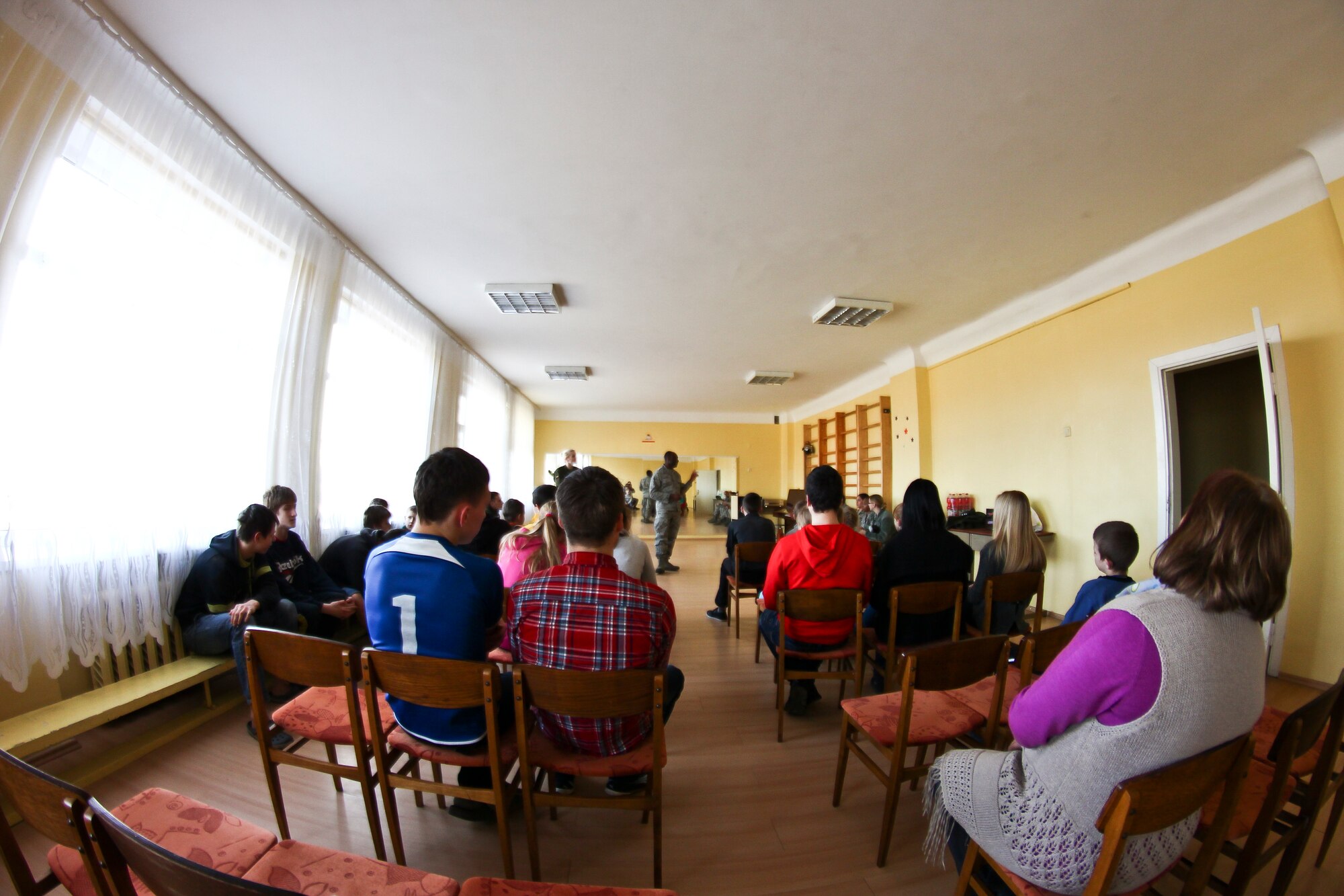 Lithuanian youths at an orphanage in Šiauliai, Lithuania listen to Chaplain (Capt.) Sean Ballard, 48th Air Expeditionary Group chaplain, discuss the capabilities of the USAF and its role in the NATO Baltic Air Policing mission March 13, 2014. Airmen from the 48th AEG spent the day visiting local orphanages, bringing gifts and donations to introduce themselves and the NATO mission to the local community and foster partnerships in the Baltics. (U.S. Air Force photo by 2nd Lt. Keenan Kunst)