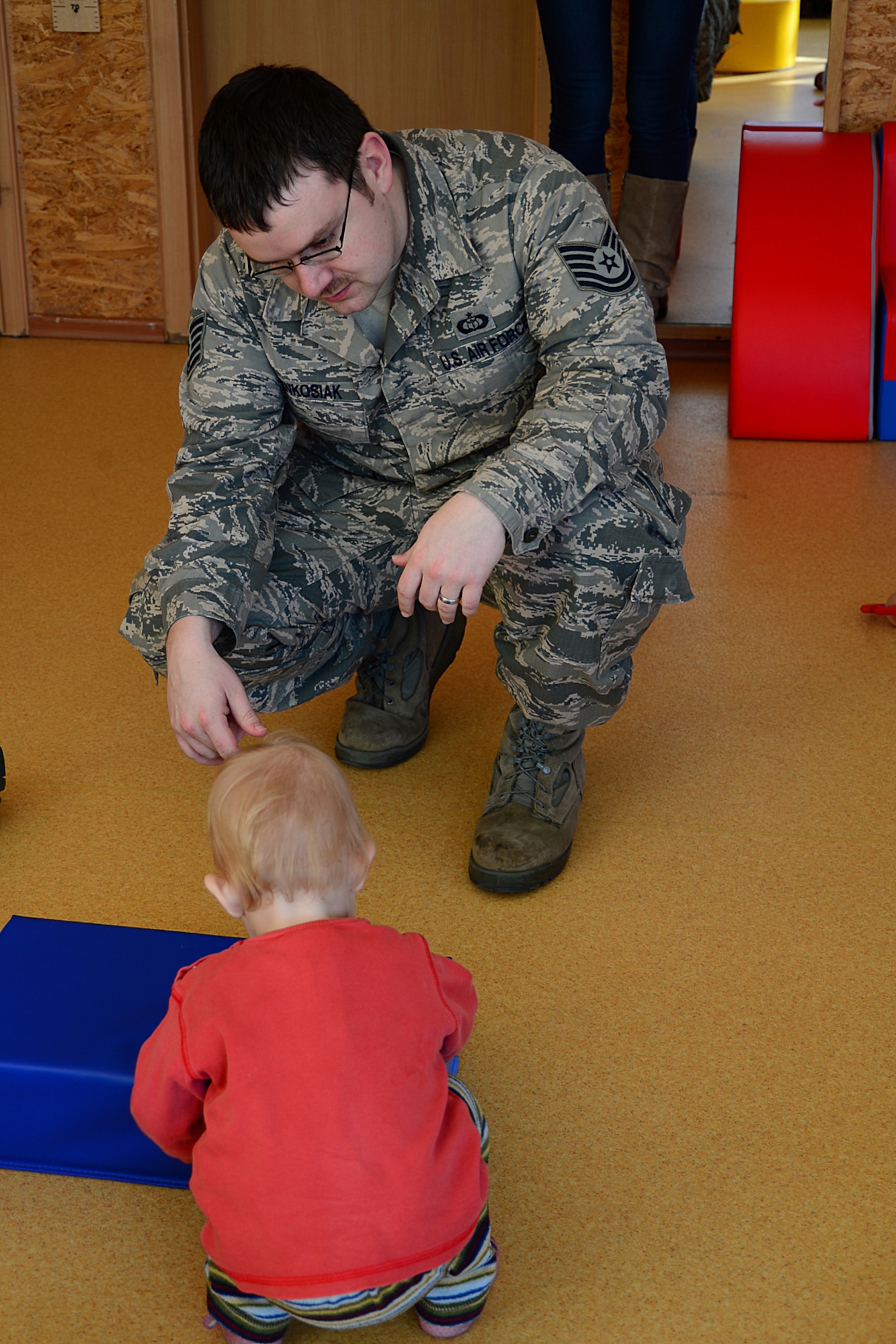 Tech Sgt. Matthew Renkosiak, 48th Air Expeditionary Group NCO in charge of weather operations, hands a toy to a child at Šiauliai City Baby’s Orphanage in Lithuania, Mar. 13, 2014. Airmen volunteered during the NATO Baltic Air Policing mission to give back to the host community. (U.S. Air Force by Airman 1st Class Dana J. Butler)  