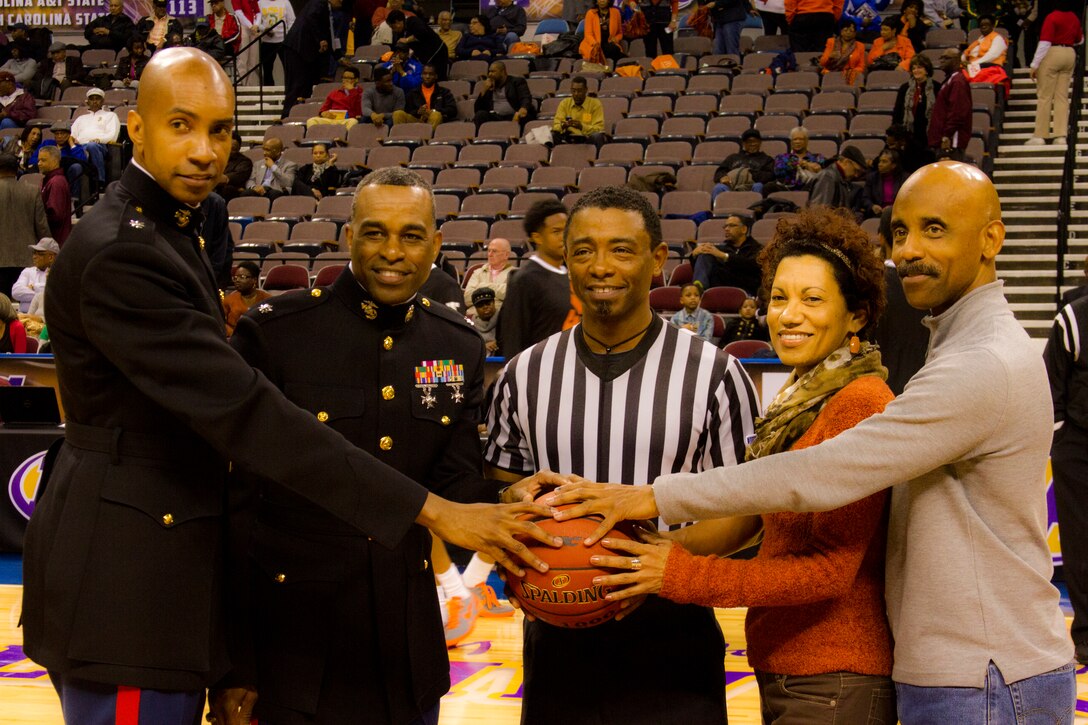 Lt. Col. Larry Parker (Left) and Lt. Col. David Rodgers (Right) pose with a ref  for the Hoops for Troops event during the 2014 Mid-Eastern Athletic Conference Basketball Tournament March 13. The Marine Corps is committed to making concerted efforts to attract, mentor, and retain the most talented men and women who bring a diversity of background, culture and skill in service to our nation.