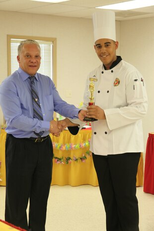 Pfc. Brandon Ruiz receives a first place trophy from Raul Torres after winning the Chef of the Quarter competition at Marine Corps Air Station Cherry Point's mess hall March 14.  During the competition, Marine chefs competed for the first place trophy and a chance to earn Chef of the Year.  Ruiz is a food service specialist with MWSS-271 and Torres is the director of supply for Cherry Point. 