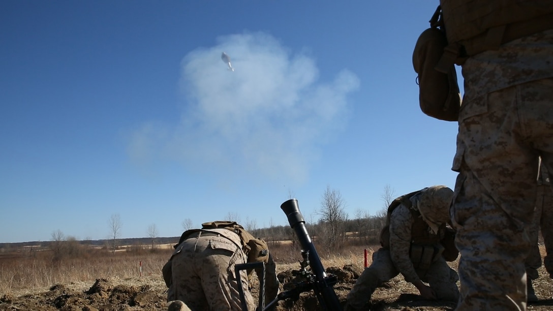 Camp Atterbury, Ind. - A 81mm mortar crew with Weapons Company, 2nd Battalion, 24th Marine Regiment, 4th Marine Division fires high-explosive rounds during a fire-for-effect mission as part of their Reserve forces drill period training, March 15, 2014, at a firing range on Camp Atterbury Joint Maneuver Center. In addition to HE rounds, the teams also fired illumination rounds as the day turned to night to give better views of targets. (Marine Corps photo by Cpl. J. Gage Karwick/released)