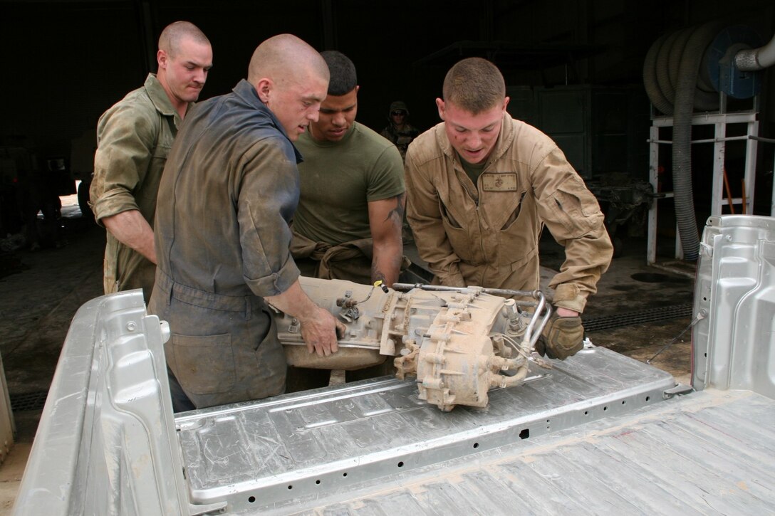 Marines with Combat Logistics Company, Combat Logistics Battalion 7 work together to put a transmission in the back of one of their vehicles aboard Camp Shorabak, Helmand province, Afghanistan, March 12, 2014. The mechanics with CLC, CLB-7, will repair and reinstall the transmission in one of the Afghan's tactical vehicles.