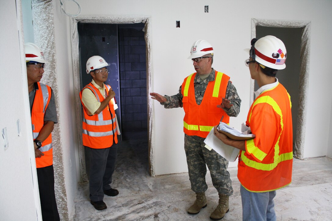 Inside a freshly painted new barracks suite at the Warriors in Transition (WIT) project, Maj. Gen. Todd T. Semonite, U.S. Army Corps of Engineers Deputy Commander and Deputy Chief of Engineers (second from right), tells Warriors in Transition (WIT) project manager Mike Onuma (right), Schofield Barracks Area Engineer Dickson Ma (left), Schofield Area Office Resident Engineer Jason Tanaka and Schofield Barracks Area Office Resident Engineer Jason Tanaka, about specific items Soldeirs would be looking for in the new suite-type barracks rooms.  Photo by Dino W. Buchanan