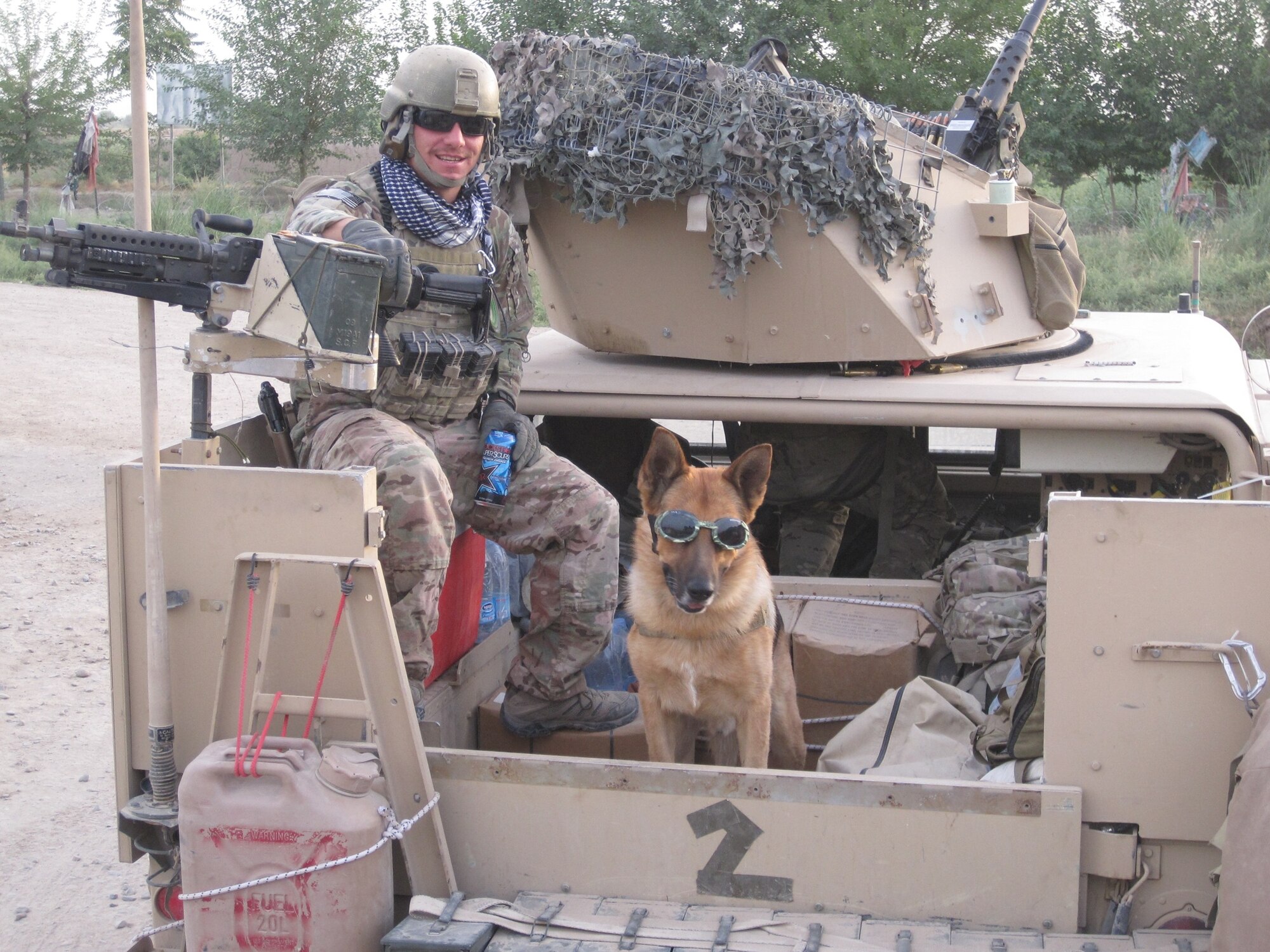 Staff Sgt. Jason Spangenberg, 436th Security Forces Squadron military working dog handler, sits with his military working dog “Rico”, while deployed July 7, 2013, in Afghanistan. Spangenberg earned the Bronze Star Medal because of his support of Army Special Operations forces. (Courtesy Photo)