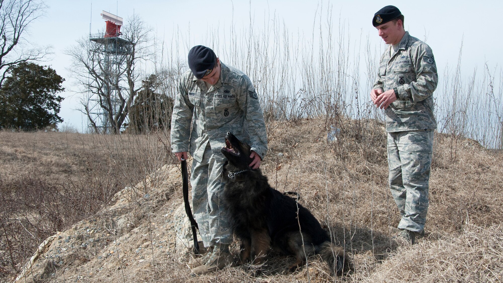 Staff Sgt. Jason Spangenberg, 436th Security Forces Squadron military working dog handler, walks with Staff Sgt. Andrew Bowmen, 436th SFS military working dog handler, and his military working dog “Terry” March, 11, 2013, at Dover Air Force Base, Del. Spangenberg supported Army Special Operations forces in more than 100 combat missions in earning the Bronze Star Medal during his recent deployment to Afghanistan. (U.S. Air Force photo/Senior Airman Jared Duhon)