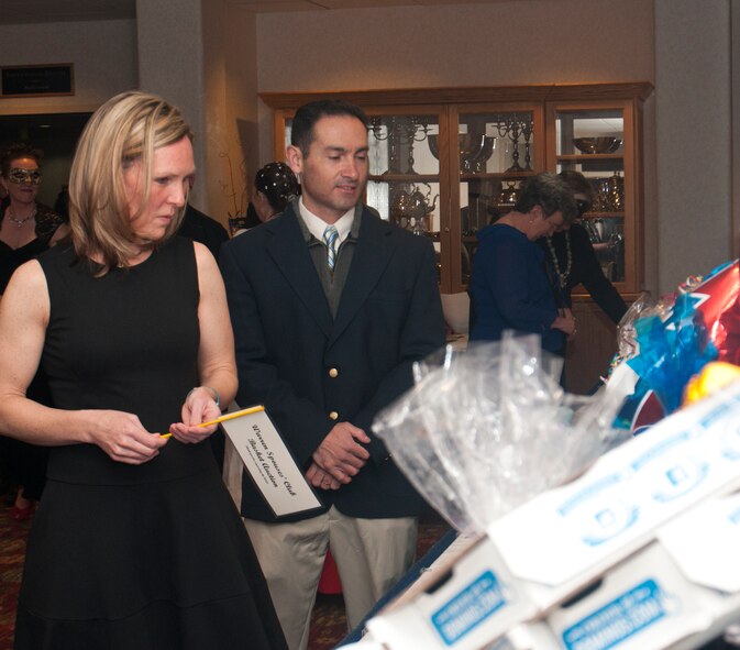 Patsy Aguirre and her husband, Lt. Col. Peter Aguirre, 90th Missile Wing Safety chief, look at the baskets available at the silent auction during the 8th Annual Warren Spouses Club Basket Auction & Masquerade March 15, 2014, in the Trail’s End Club. The auction included silent and live segments. (U.S. Air Force photo by Airman 1st Class Jason Wiese)