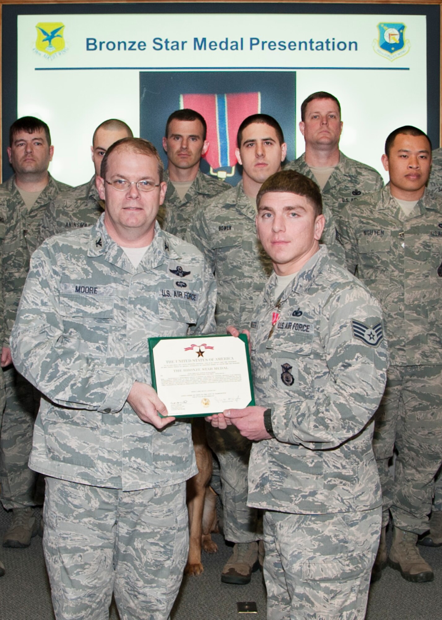 Staff Sgt. Jason Spangenberg, 436th Security Forces Squadron dog handler, poses with Col. Rick Moore, 436th Airlift Wing commander, after receiving the Bronze Star Medal March 4, 2014, at Dover Air Force Base, Del. Spangenberg supported Army Special Operations forces in more than 100 combat mission during his deployment. (U.S. Air Force photo/Senior Airman Jared Duhon)