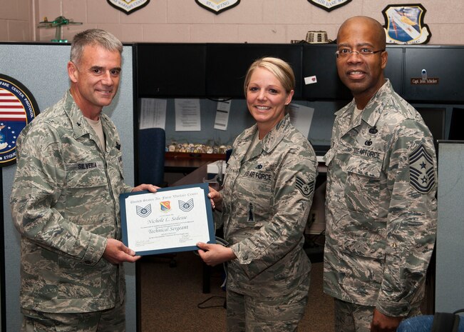 U.S. Air Force Staff Sgt. Nichole Sedesse (center), United States Air Force Warfare Center protocol ceremonial NCO, stands with U.S. Air Force Brig. Gen. Jay Silveria (right), USAFWC commander, and U.S. Air Force Command Chief Master Sgt. Robert Ellis (left), USAFWC command chief, after being STEP promoted to the rank of Technical Sgt. at the USAFWC March 17, 2014, Nellis Air Force Base, Nev. The STEP promotion program offers commanders a limited opportunity to immediately promote enlisted members to staff sergeant, technical sergeant, and master sergeant. (U.S. Air Force photo by Airman 1st Class Thomas Spangler)
