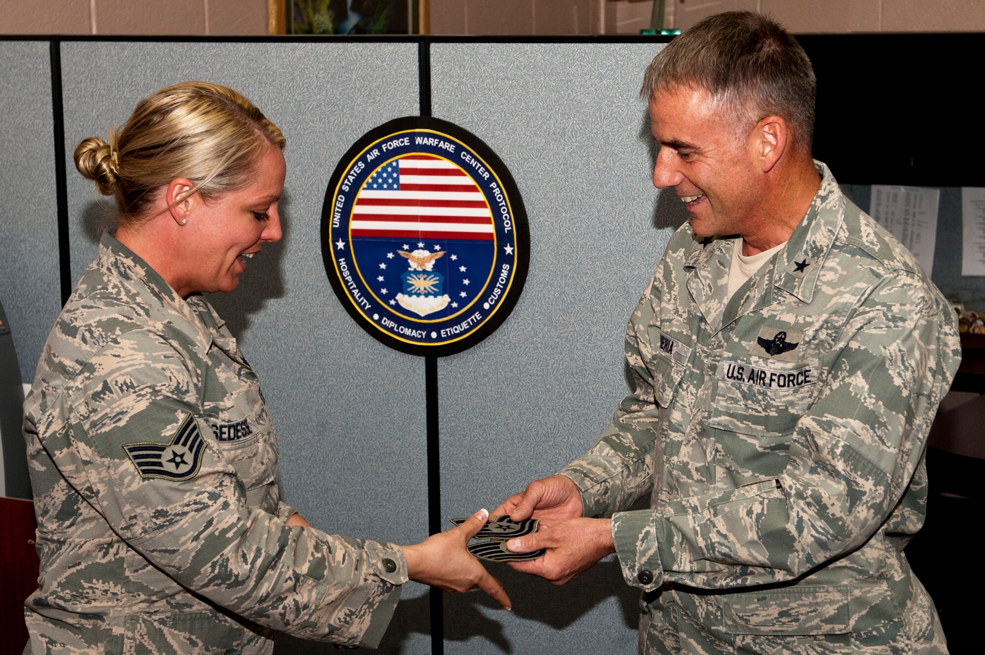 U.S. Air Force Brig. Gen. Jay Silveria, United States Air Force Warfare Center commander, awards Tech. Sgt. stripes to Staff Sgt. Nichole Sedesse, USAFWC protocol ceremonial NCO, during a STEP promotion ceremony at the USAFWC March 17, 2014, Nellis Air Force Base, Nev. The STEP program, established in 1980, is designed to meet those unique circumstances that, in the commander’s judgment, clearly warrant promotion. (U.S. Air Force photo by Airman 1st Class Thomas Spangler)