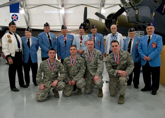 DOVER AIR FORCE BASE, Del. – Kneeling from left to right, Capt. Phillip Zencey, Master Sgt. Jason Sawicki, Senior Master Sgt. Joseph Barden and Senior Airman Paul Cardona, 66th Security Forces Squadron personnel, pose with nine members of the Delaware Chapter of the Korean War Veterans Association inside the Air Mobility Command Museum March 15. The Airmen won the team competition at the 15th Annual 436th Security Forces Ruck March held at Dover Air Force Base to commemorate the Korean War Battle of Chosin Reservoir. (U.S. Air Force photo/Airman 1st Class Zachary Cacicia)