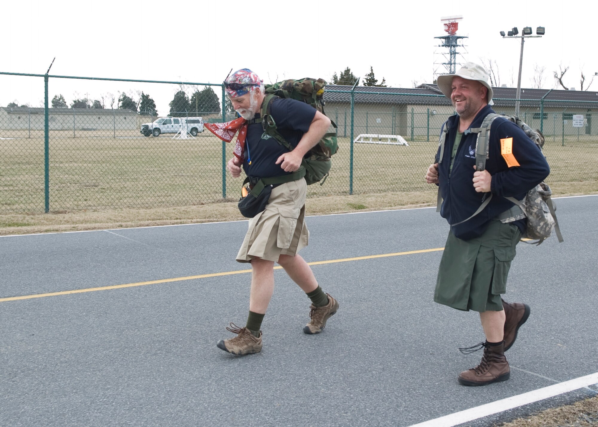 David Brown, left, and Greg Davis, 436th Airlift Wing Public Affairs photojournalist, run down Perimeter Road March 15, 2014, during the 15th Annual 436th Security Forces Ruck March at Dover Air Force Base, Del. Brown and Davis were the only two runners to wear tactical kilts during the race. (U.S. Air Force photo/Airman 1st Class Zachary Cacicia)
