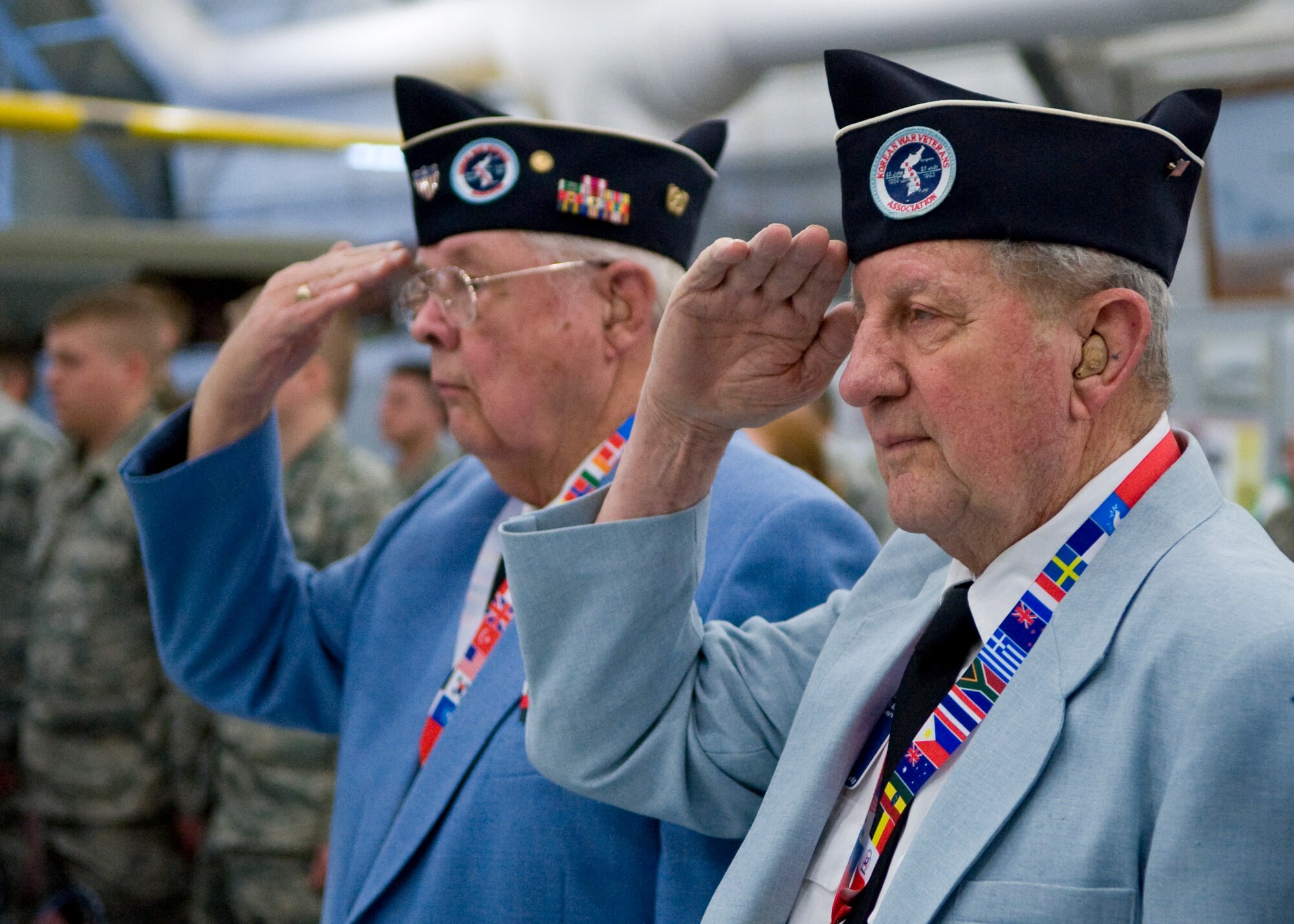 Bill Russell, left, and Paul N. Dill salute during the singing of the National Anthem at the 15th Annual 436th Security Forces Ruck March pre-event ceremony March 15, 2014, at the Air Mobility Command Museum on Dover Air Force Base, Del. Russell and Dill, veterans of the Korean War, attended this event which commemorated the Korean War Battle of Chosin Reservoir, November to December, 1950. (U.S. Air Force photo/Airman 1st Class Zachary Cacicia)