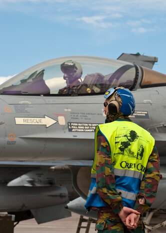 A Belgian air force crew chief and pilot prepares to marshal an F-16 Fighting Falcon during Red Flag 14-2, March 13, 2014, at Nellis Air Force Base, Nev. Red Flag provides realistic combat training in a contested, degraded and operationally limited environment. The training provides pilots with real-time war scenarios and also helps to test ground crew operational readiness. (U.S. Air Force photo by Airman 1st Class Thomas Spangler)