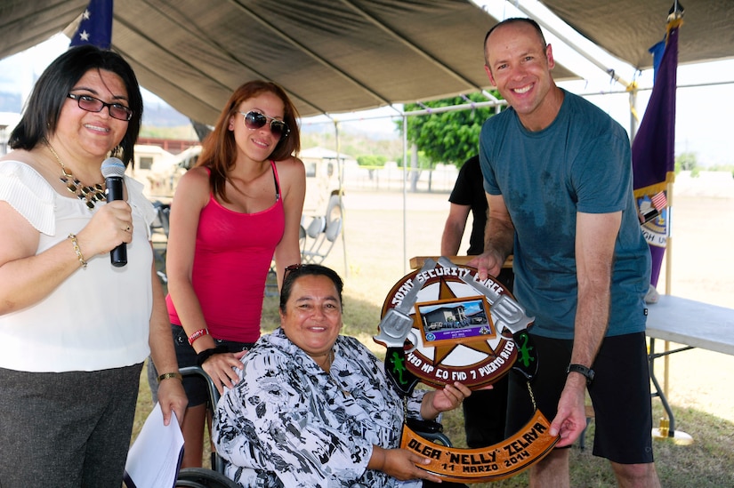 U. S. Air Force Major Robert Shaw, Joint Security Forces commander, presents Ms. Nelly Zelaya, Fundación CasAyuda founder and executive director, a commemorative wooden plaque during the “Anniversary Celebration” for the organization, March 11, 2014.  The children enjoyed lunch, swimming, jumping in a bouncy castle, playing soccer and creating arts and crafts.  (Photo by Martin Chahin)
