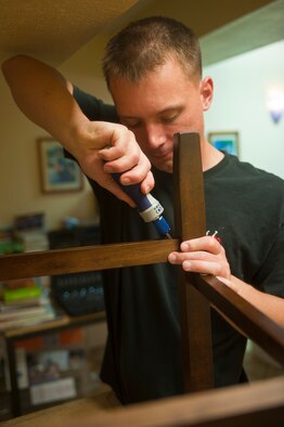 Airman 1st Class Charles Blanth, 57th Maintenance Squadron precision measurement equipment laboratory specialist, assembles a chair during the Airmen’s Center self-help restoration project March 15, 2014, at Nellis Air Force Base, Nev. The Nellis Area Spouses Club purchased the supplies for the renovation of the Airmen's Center to improve the residence quality of life. (U.S. Air Force photo by Airman 1st Class Jake Carter)