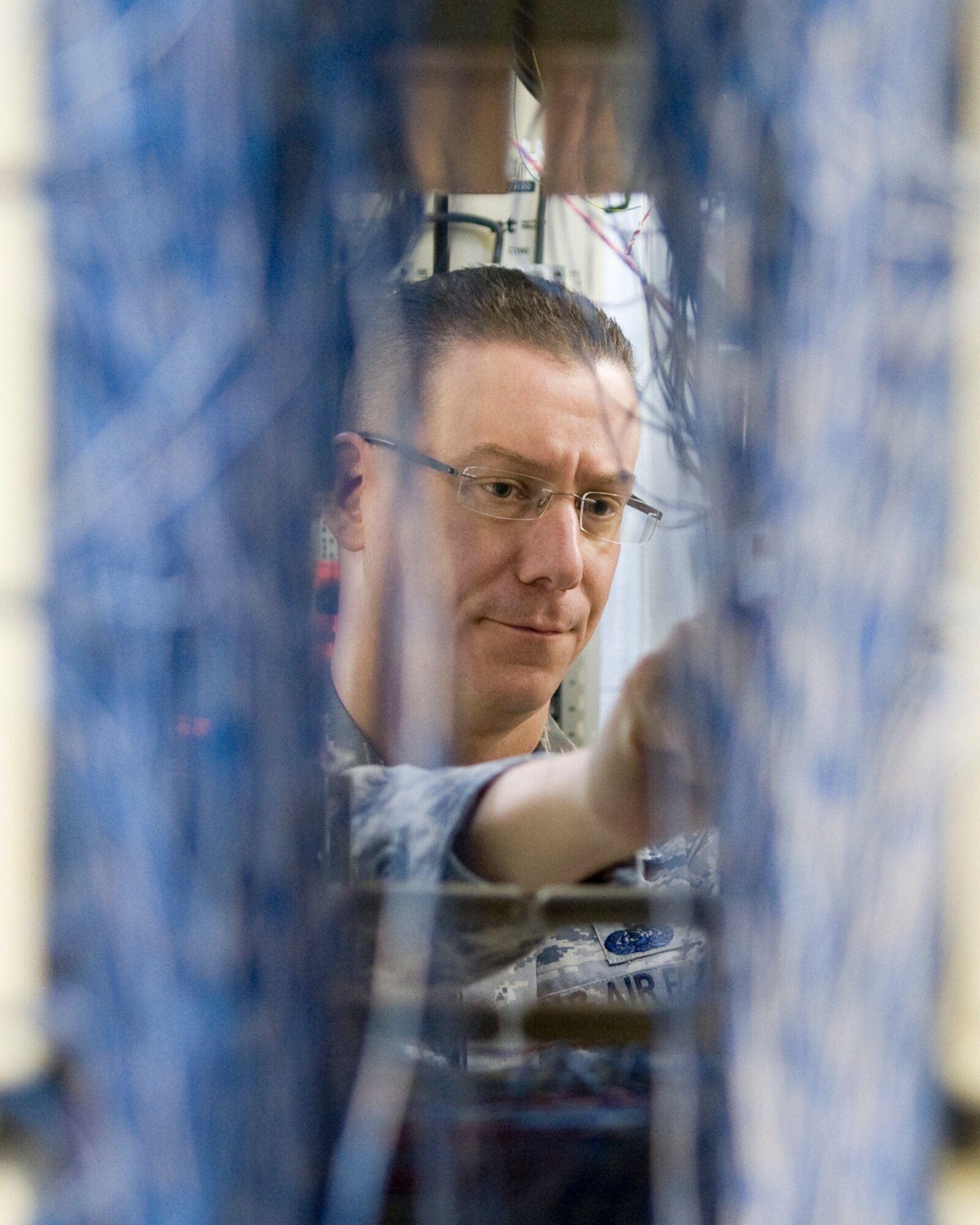Master Sgt. David White, 436th Communications Squadron plans and implementations flight superintendent, conducts maintenance work in a telephone switch room March 13, 2014, at Dover Air Force Base, Del. White won the 2013 Air Force Outstanding Cyberspace Systems Senior Non-Commissioned Officer Award. (U.S. Air Force photo/Airman 1st Class Zachary Cacicia)