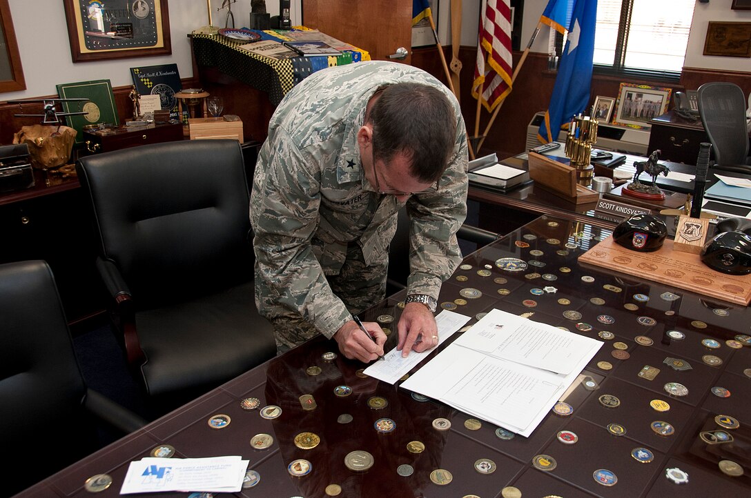 Brig. Gen. Scott Kindsvater, 82nd Training Wing Commander signs a pledge for the Air Force Assistance Fund in the 82nd TRW office March 18, 2014.  AFAF is one of only two official fundraisers. (U.S. Air Force photo/Airman 1st Class Robert L. McIlrath)