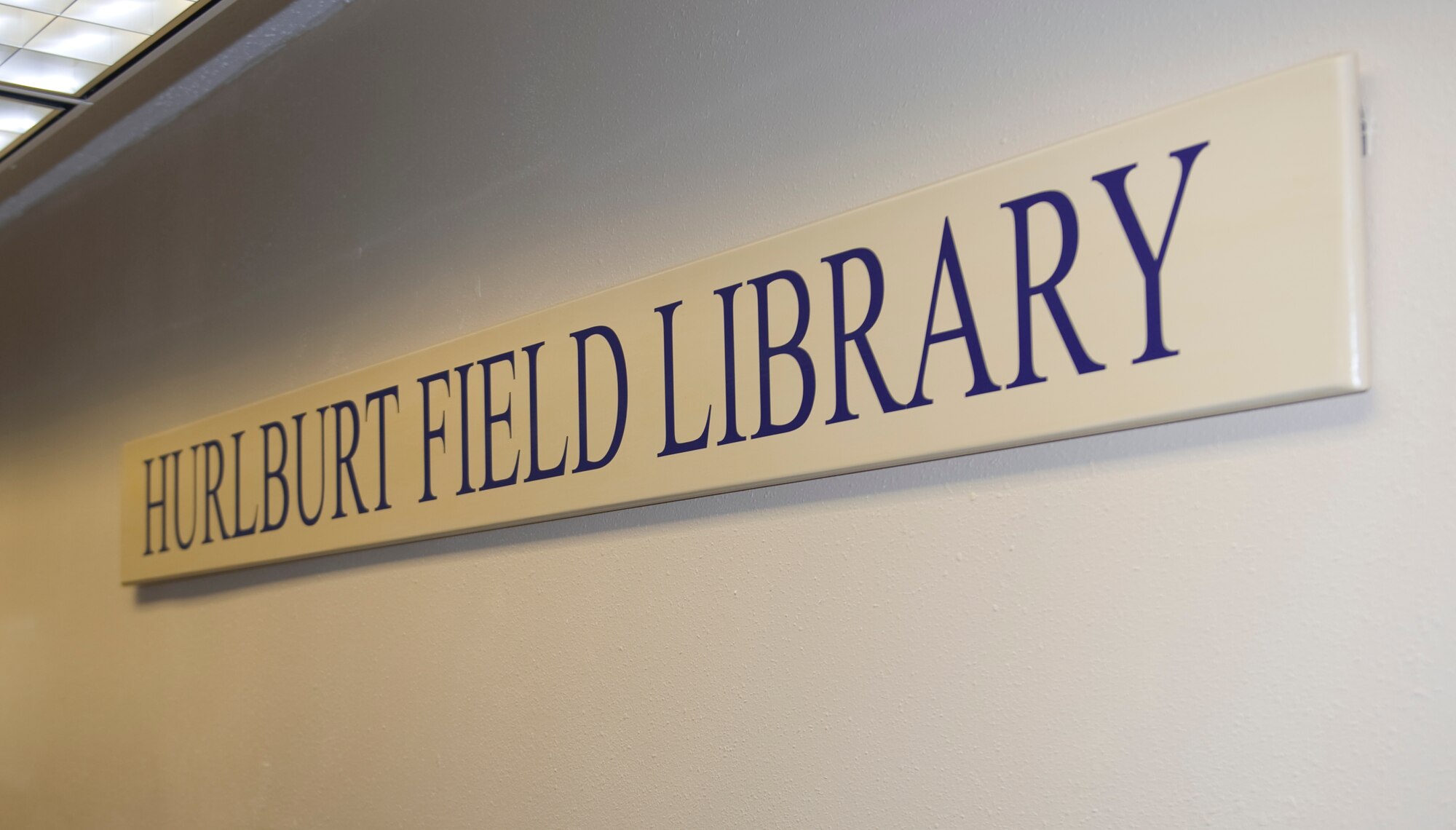 The base library sign hangs on a wall inside of the library at Hurlburt Field, Fla., March 18, 2014.  The library houses approximately 47,000 items including hard back books, DVD’s, audio books and magazines. (U.S. Air Force photo/Senior Airman Naomi Griego)