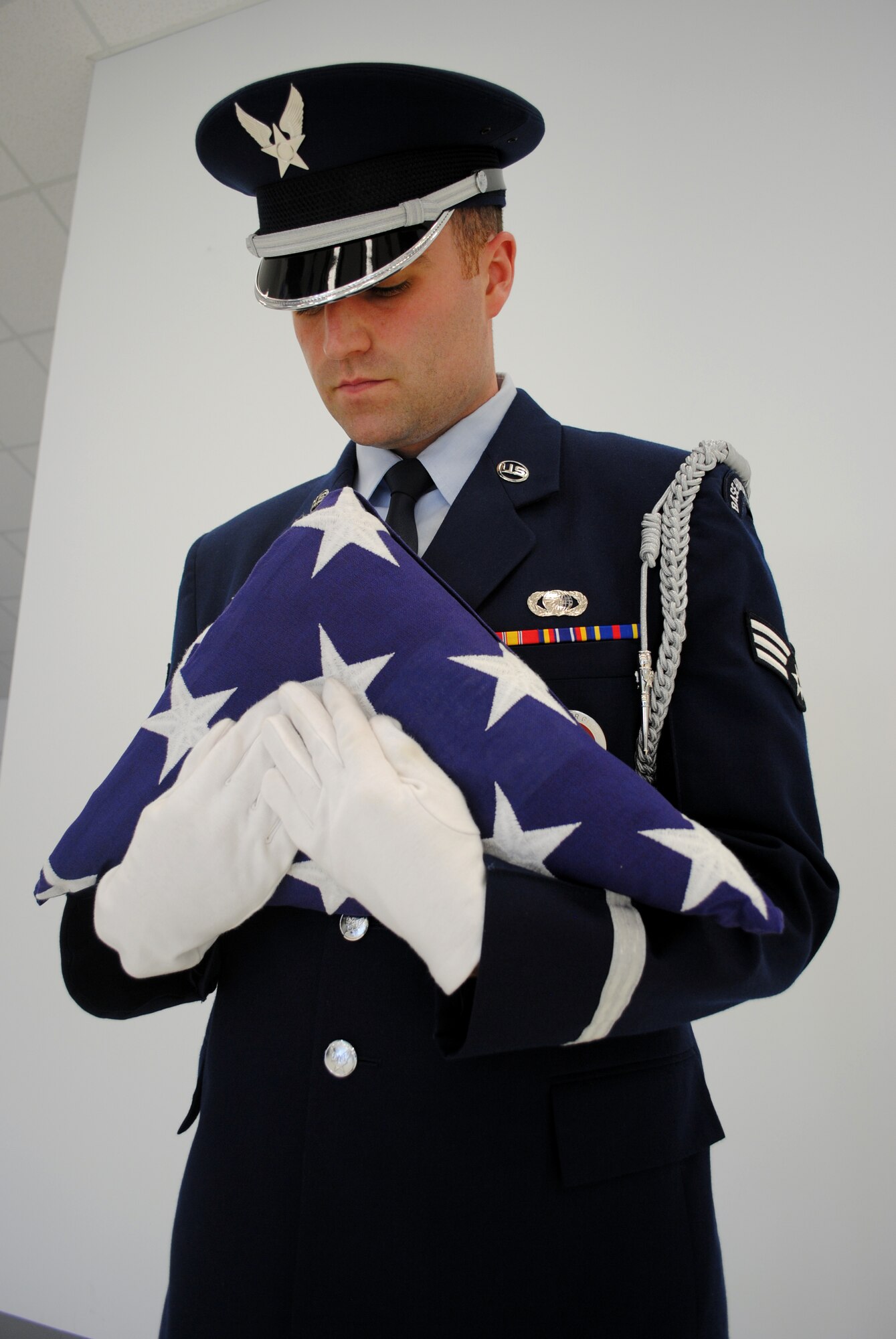 Senior Airman Jeffrey M. Lowder demonstrates the proper way of dressing a U.S. flag during a training session on May 21, 2013, at the Honor Guard Building on Grand Forks Air Force Base, N.D. The three-year Air Force veteran from Camden, S.C., is assigned to the 319th Comptroller Squadron. (U.S. Air Force photo/Staff Sgt. Luis Loza Gutierrez)