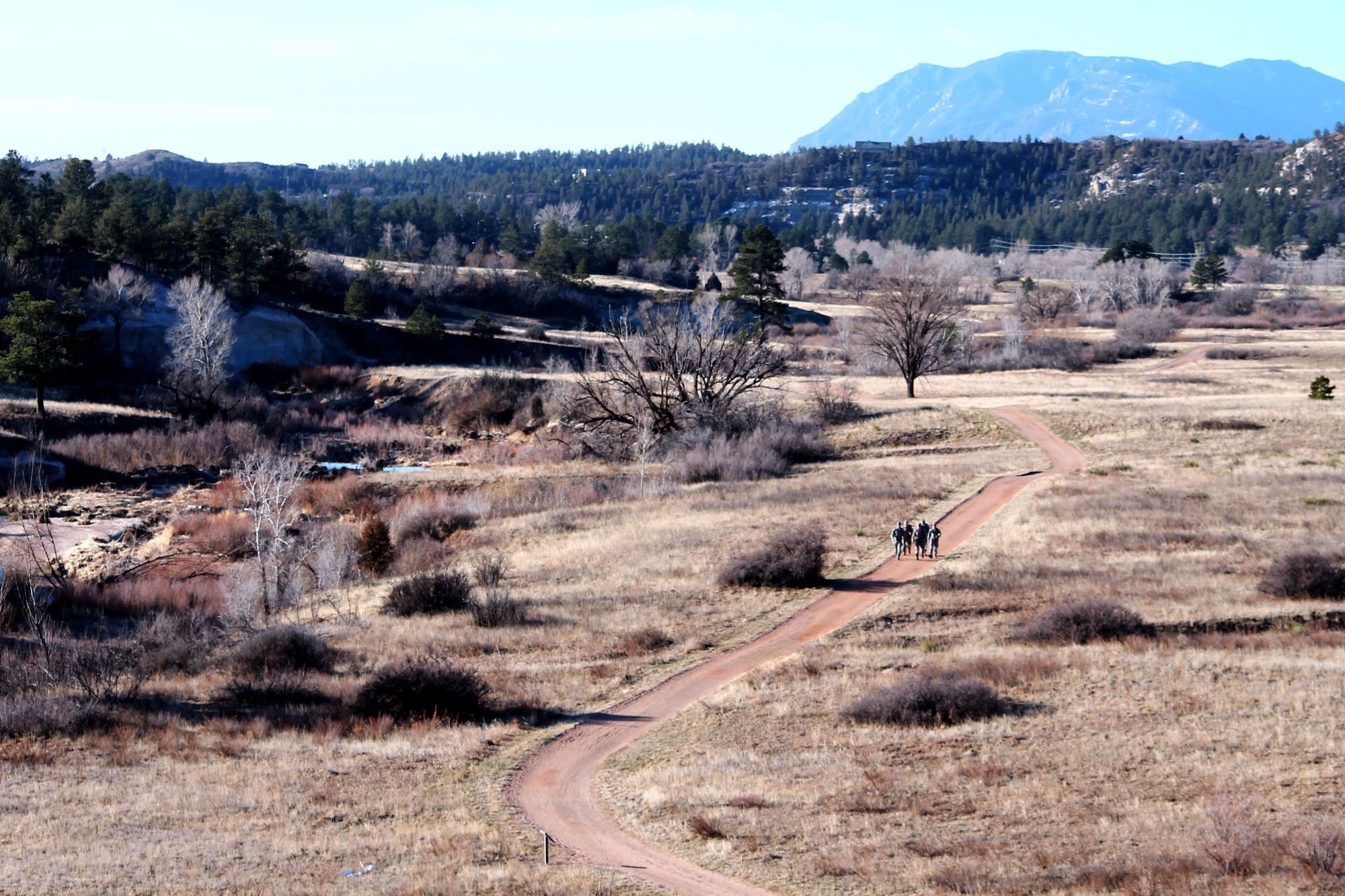 SANTA FE TRAIL, Colo. — With Cheyenne Mountain in the background, five of the eight Airmen participating in the annual 26.2 mile Bataan Memorial Death March at White Sands Missile Range, N.M., set out on their final practice march. The march is a yearly event to honor the victims and survivors of the forced march of American prisoners of war in the Philippines during World War II. The Airmen will each be carrying a 35-pound patrol pack full of non-perishable food items that will be donated to a New Mexico food bank. Last year the march produced nearly 14,000 pounds of food for the food bank. (U.S. Air Force photo/Michael Golembesky)